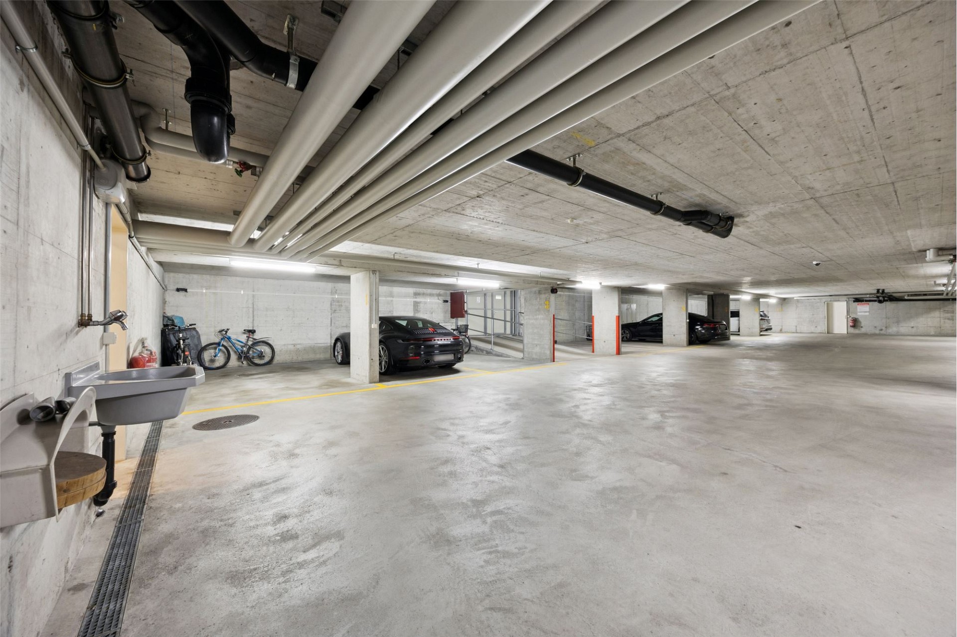 Tiefgarage mit Rohbeton und Fahrzeugen