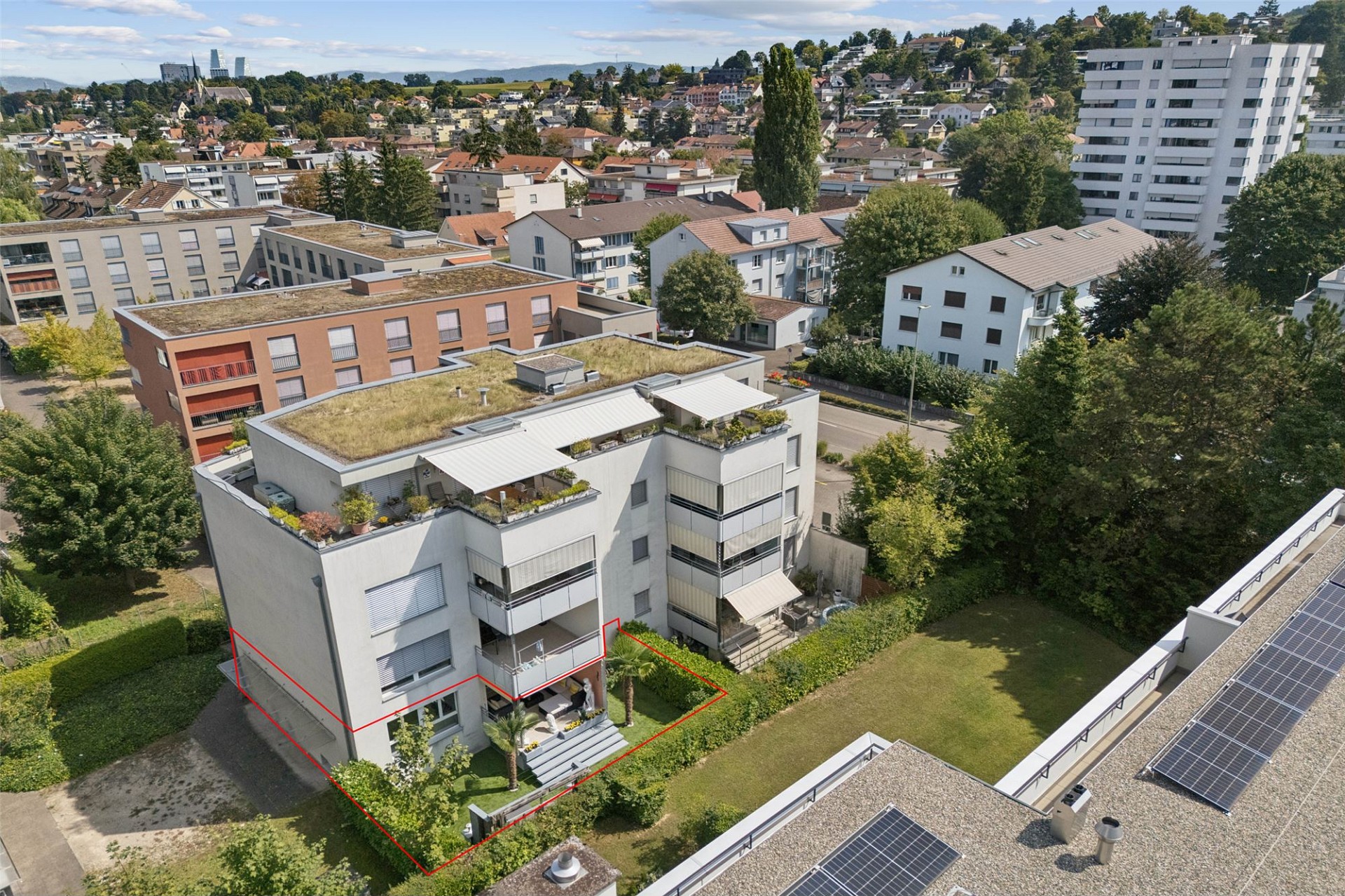 Luftaufnahme eines Wohnquartiers mit Flachdach-Mehrfamilienhäusern und Grünflächen