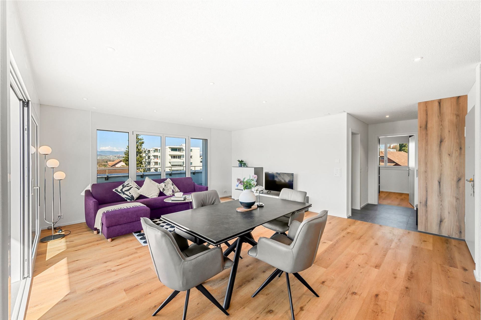 Helles Wohn- und Esszimmer mit Balkonblick