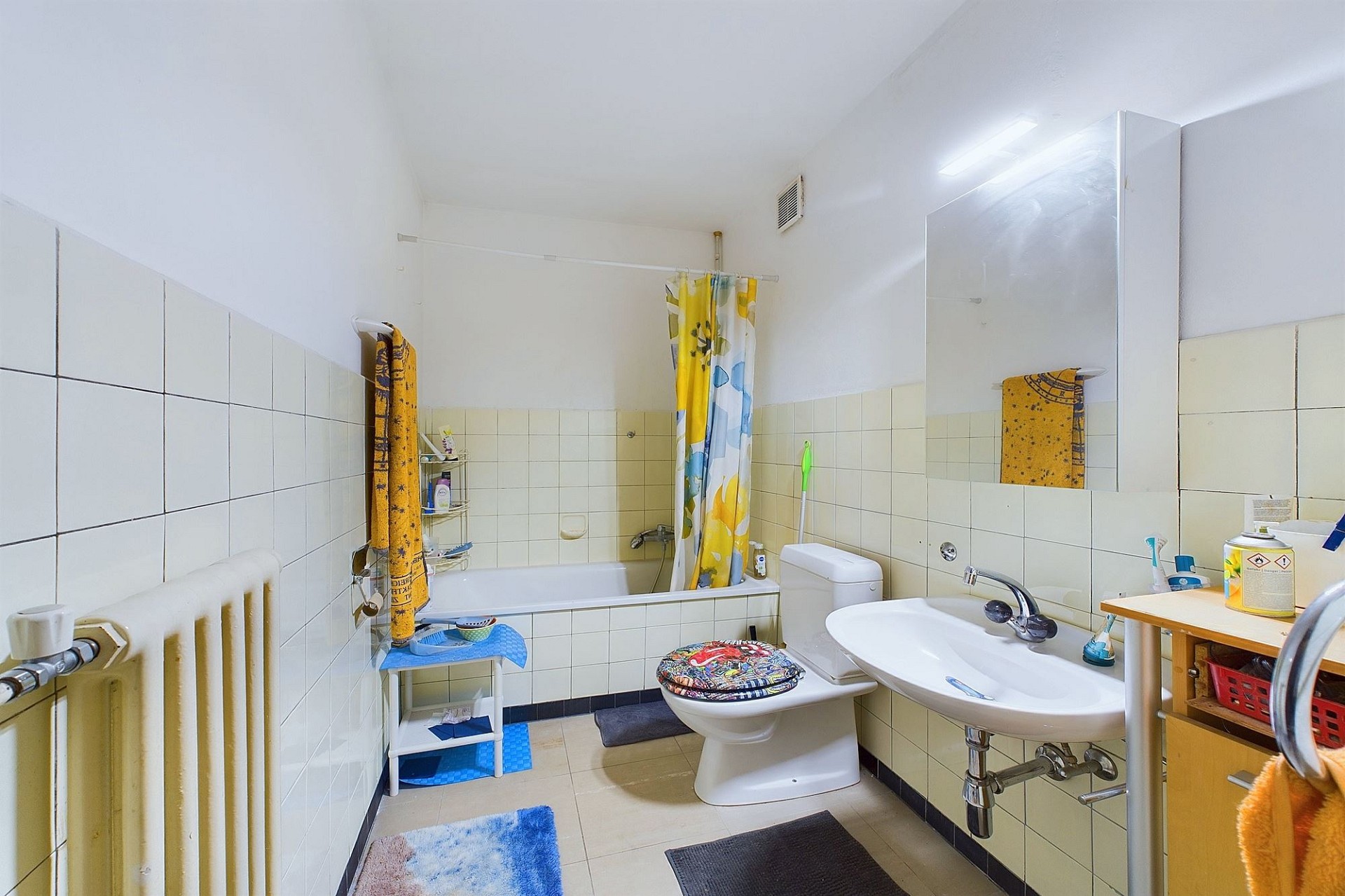 Kleines Badezimmer mit Badewanne, Waschbecken und WC