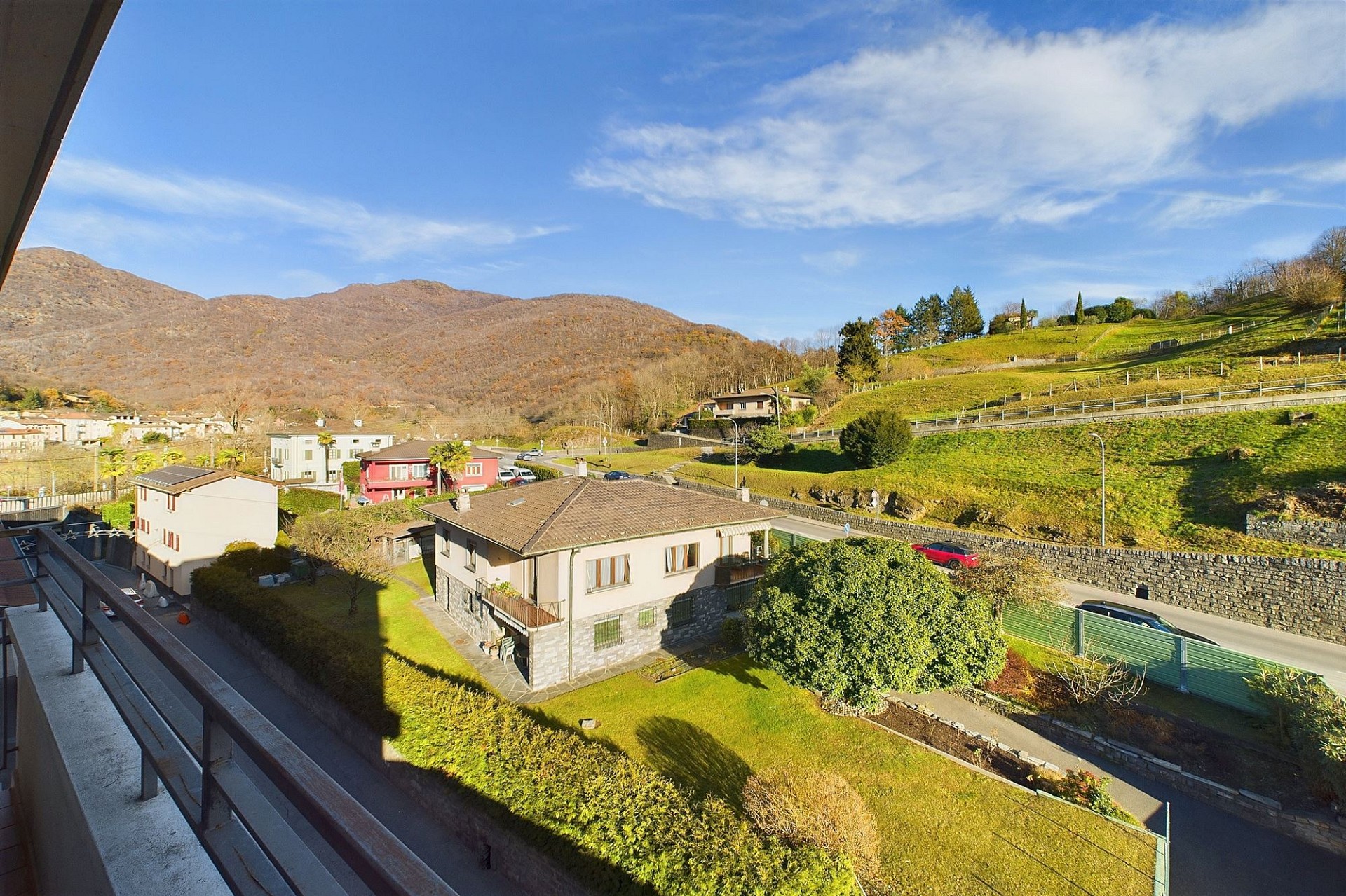Blick vom Balkon auf Wohnhäuser und Hügellandschaft