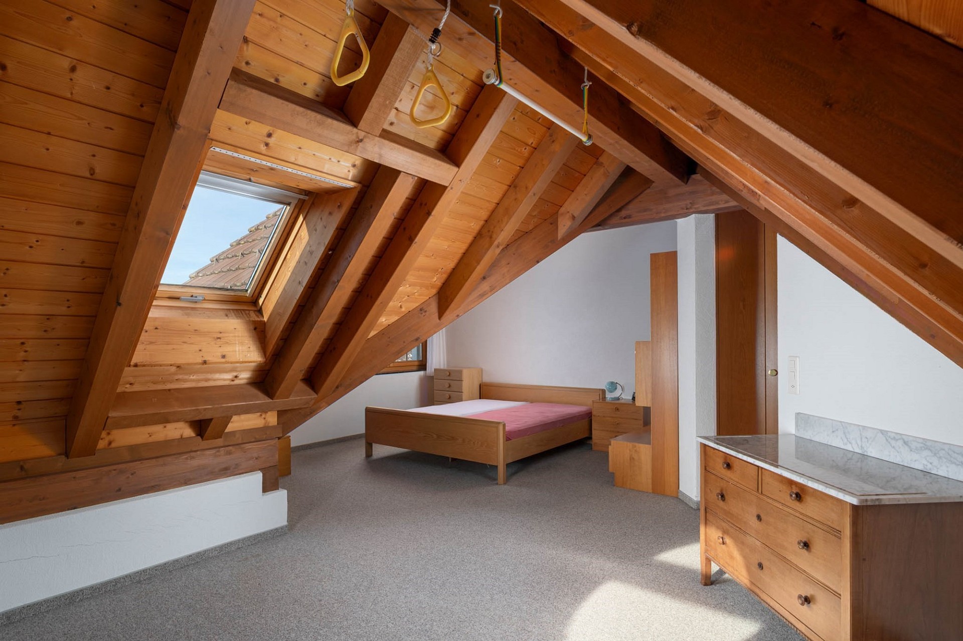 Dachgeschoss-Schlafzimmer mit Holzbalken