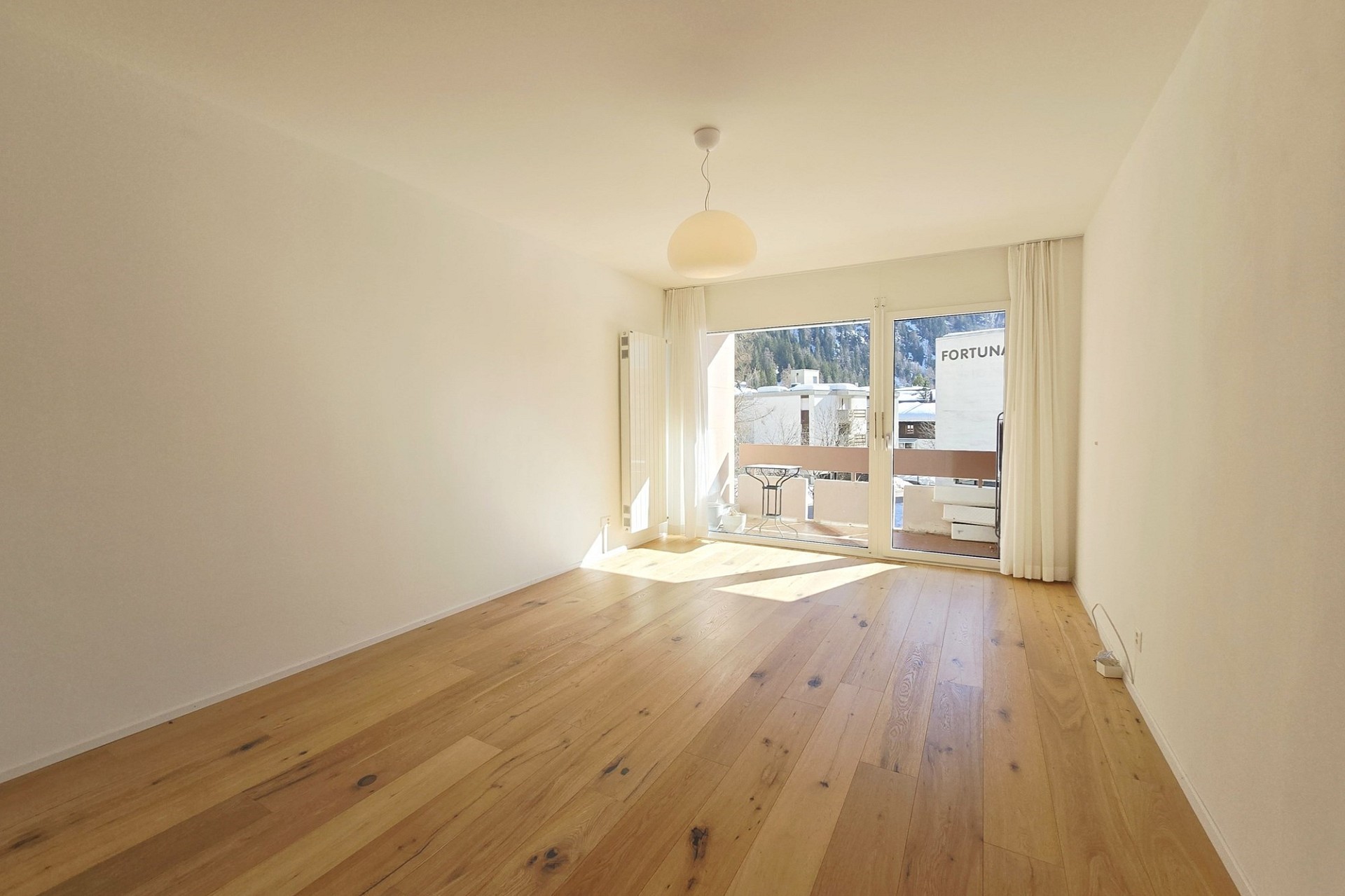 Heller, leerer Wohnraum mit Balkonblick