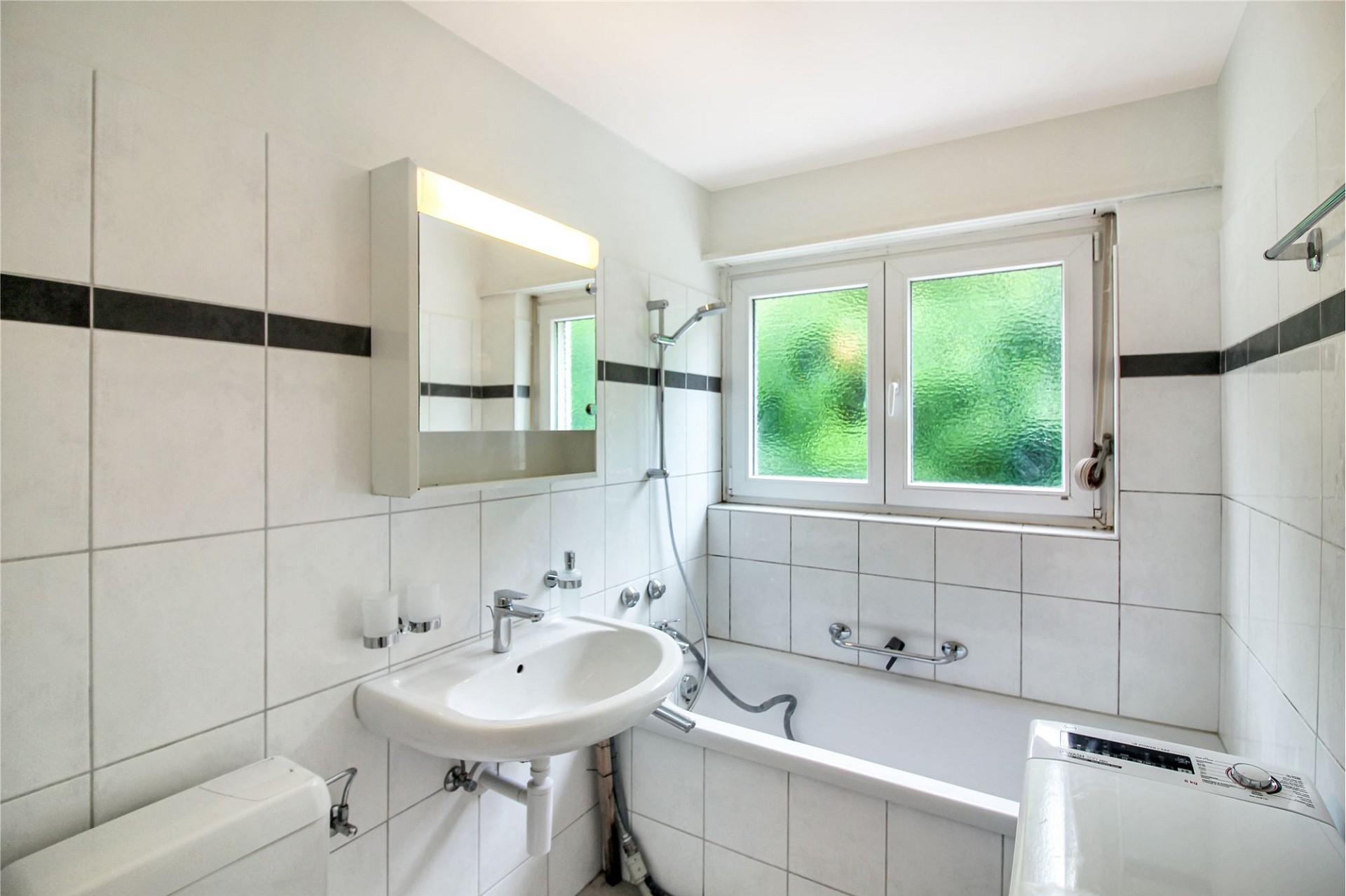 Kleines, helles Badezimmer mit Badewanne