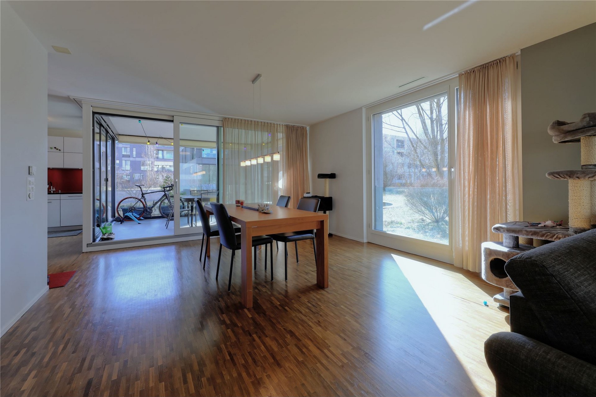 Helles Wohn-Esszimmer mit Balkon und großen Fenstern