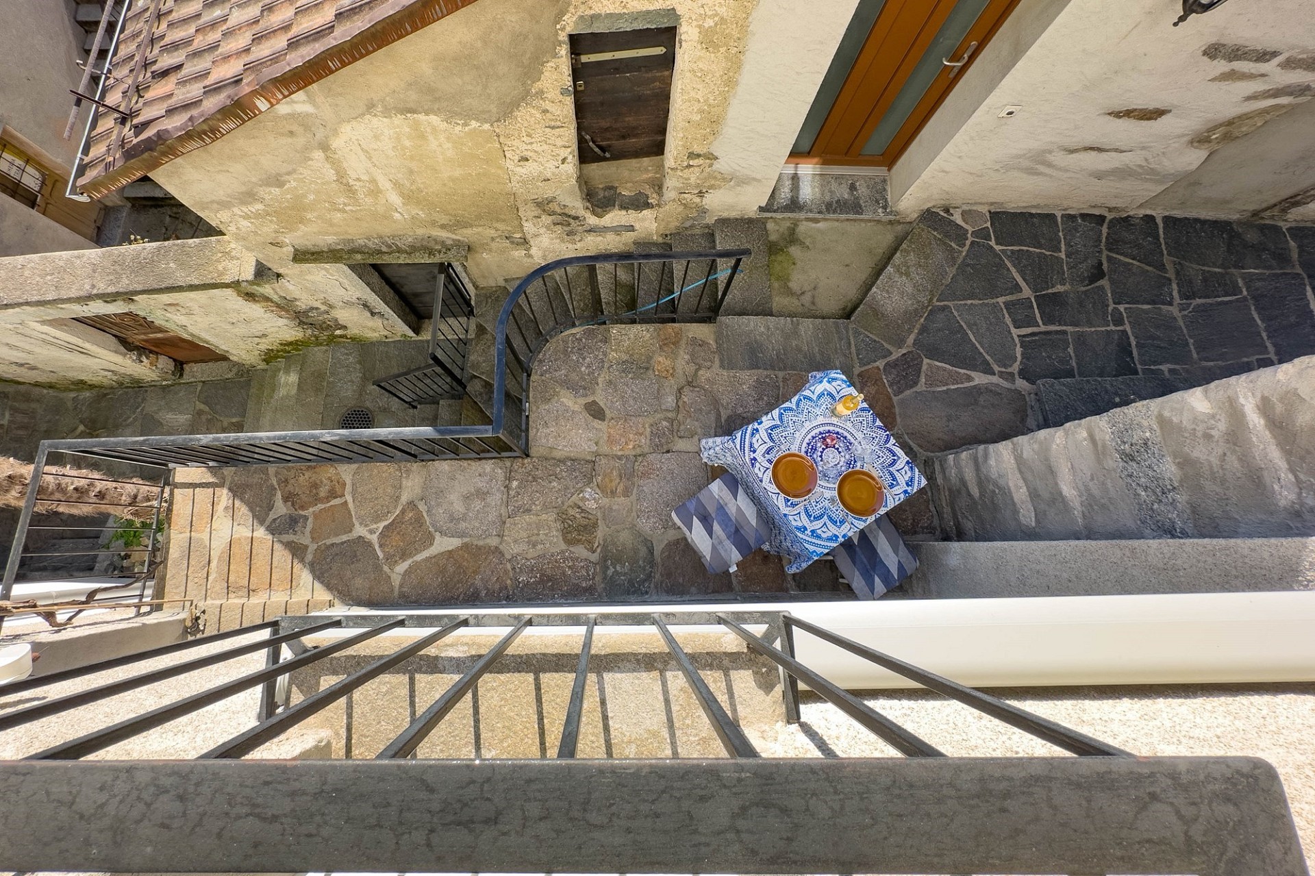 Blick auf einen verwinkelten Außenhof mit Treppen und Steinbelag