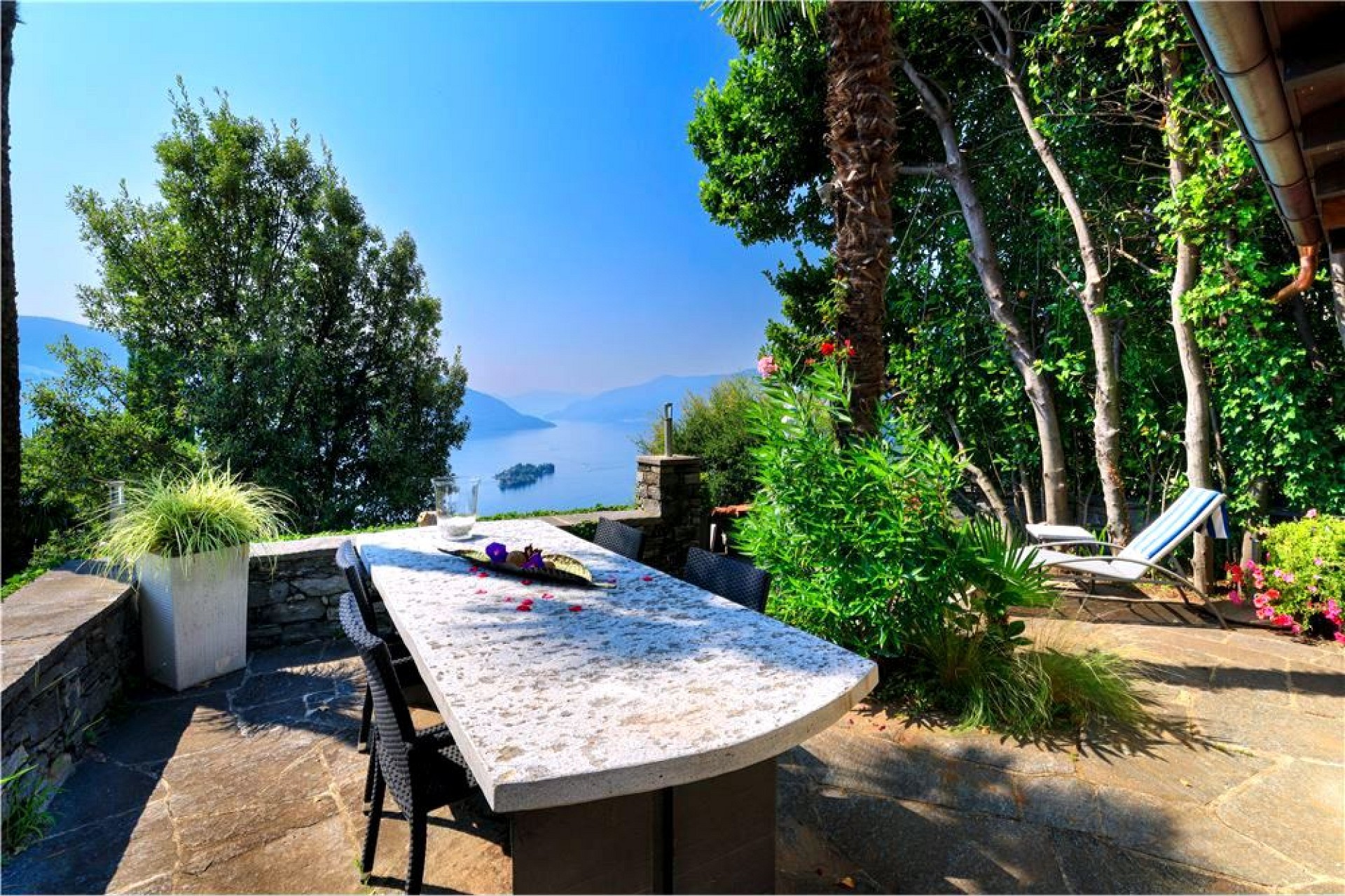 Terrasse mit Seeblick und Gartenmöbeln