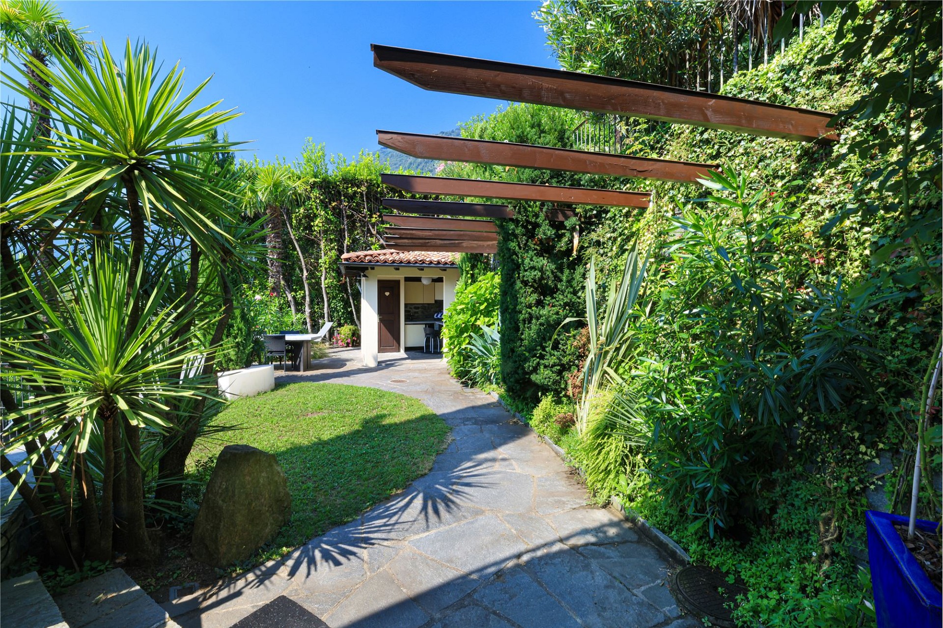 Tropischer Garten mit Pergola und Gartenzugang