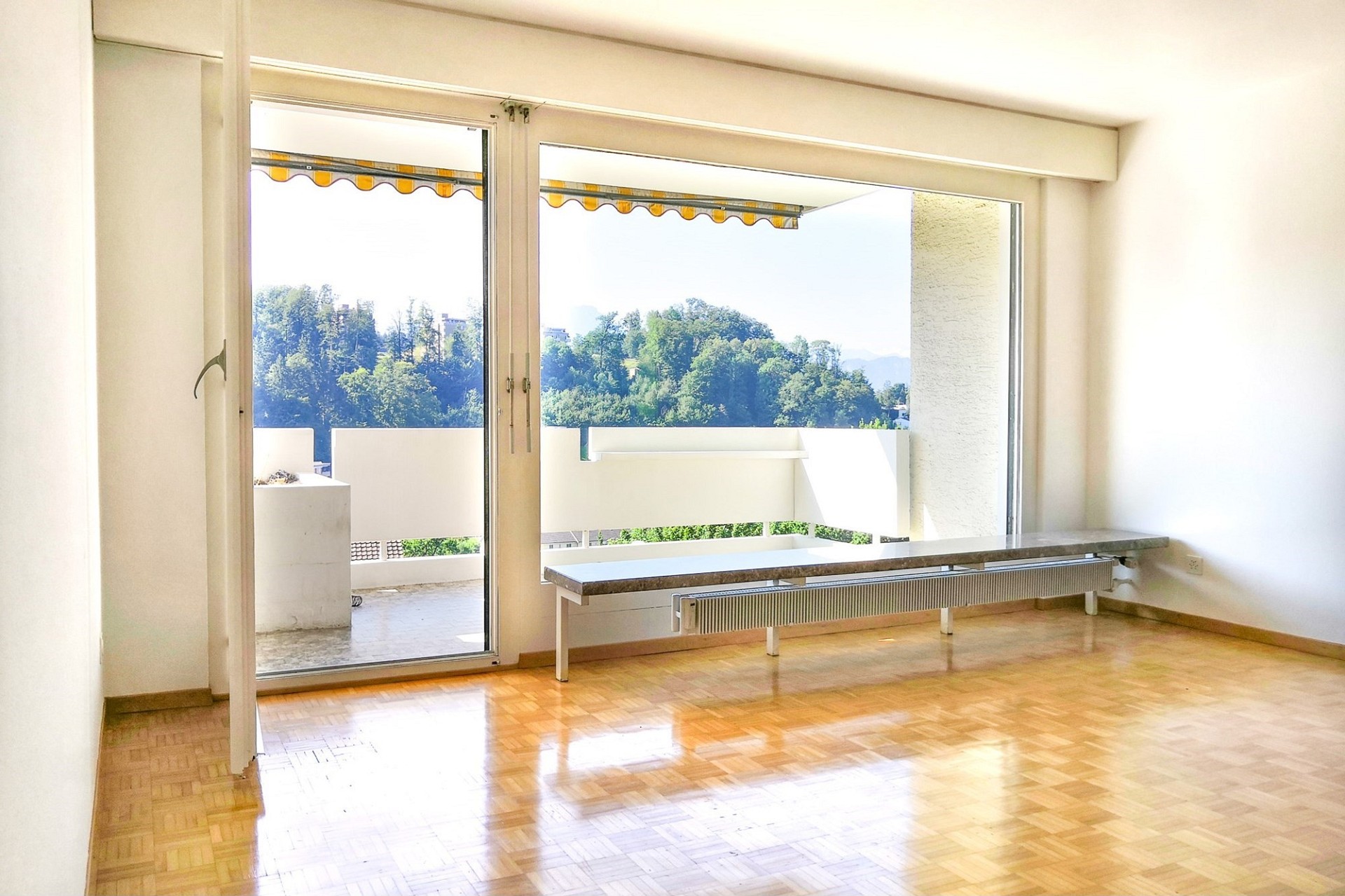 Helles Wohnzimmer mit Balkon und Ausblick ins Grüne