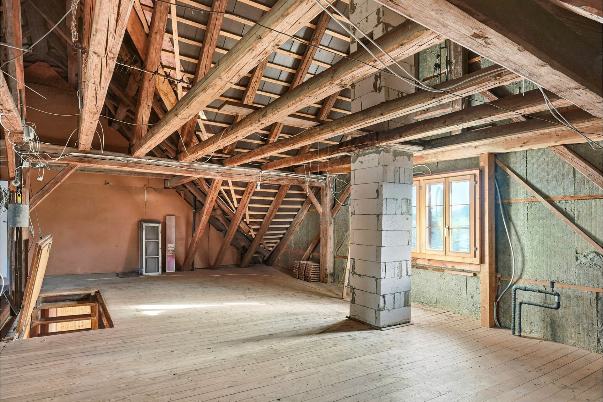 Dachboden im Rohbau mit sichtbarer Holzkonstruktion