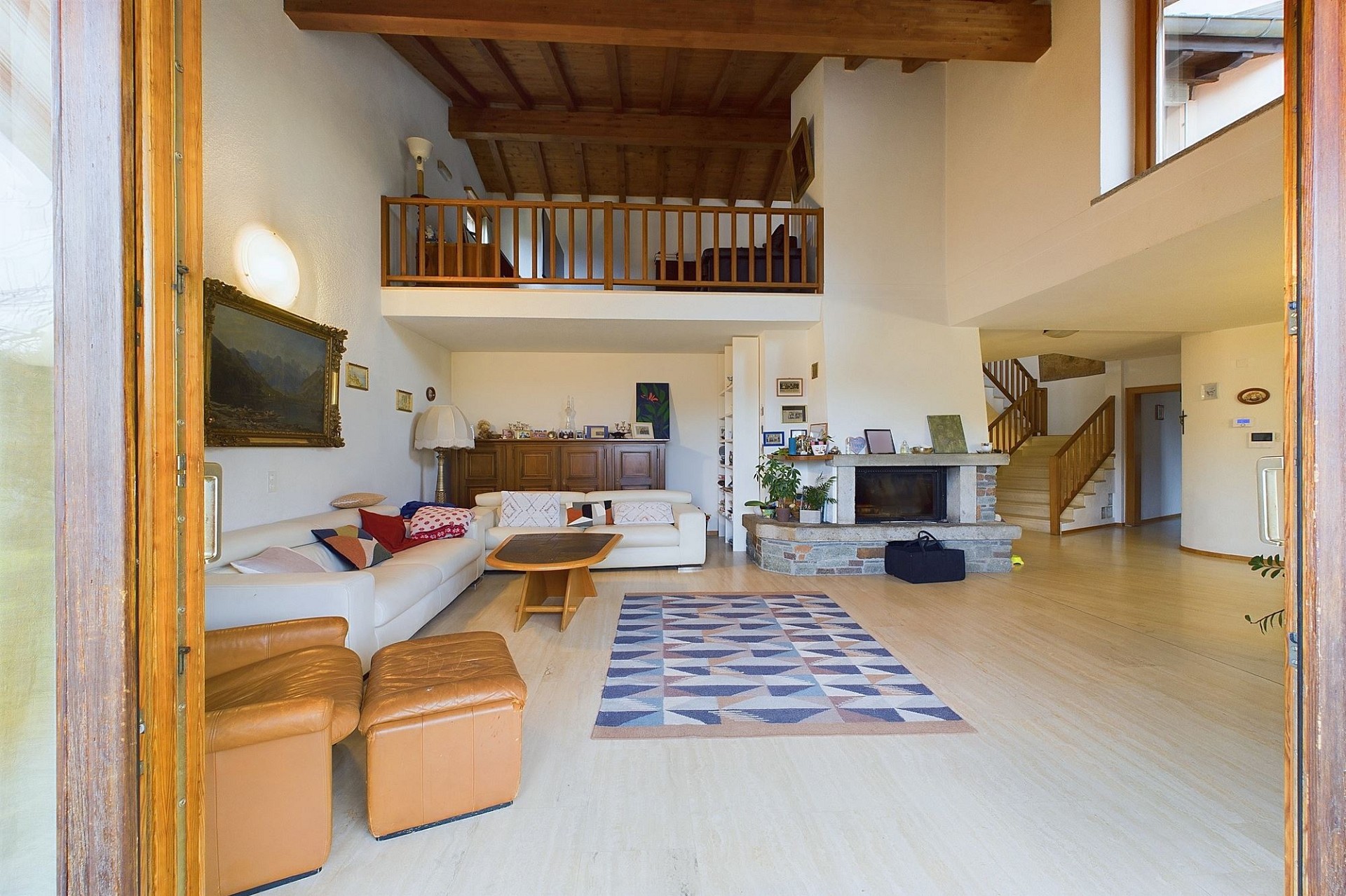 Großzügiges Wohnzimmer mit Galerie und Kamin