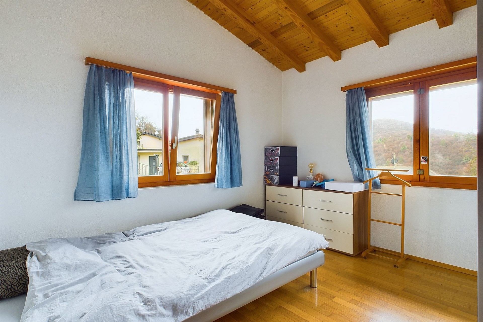 Helles Schlafzimmer mit Holzdecke und Bergblick