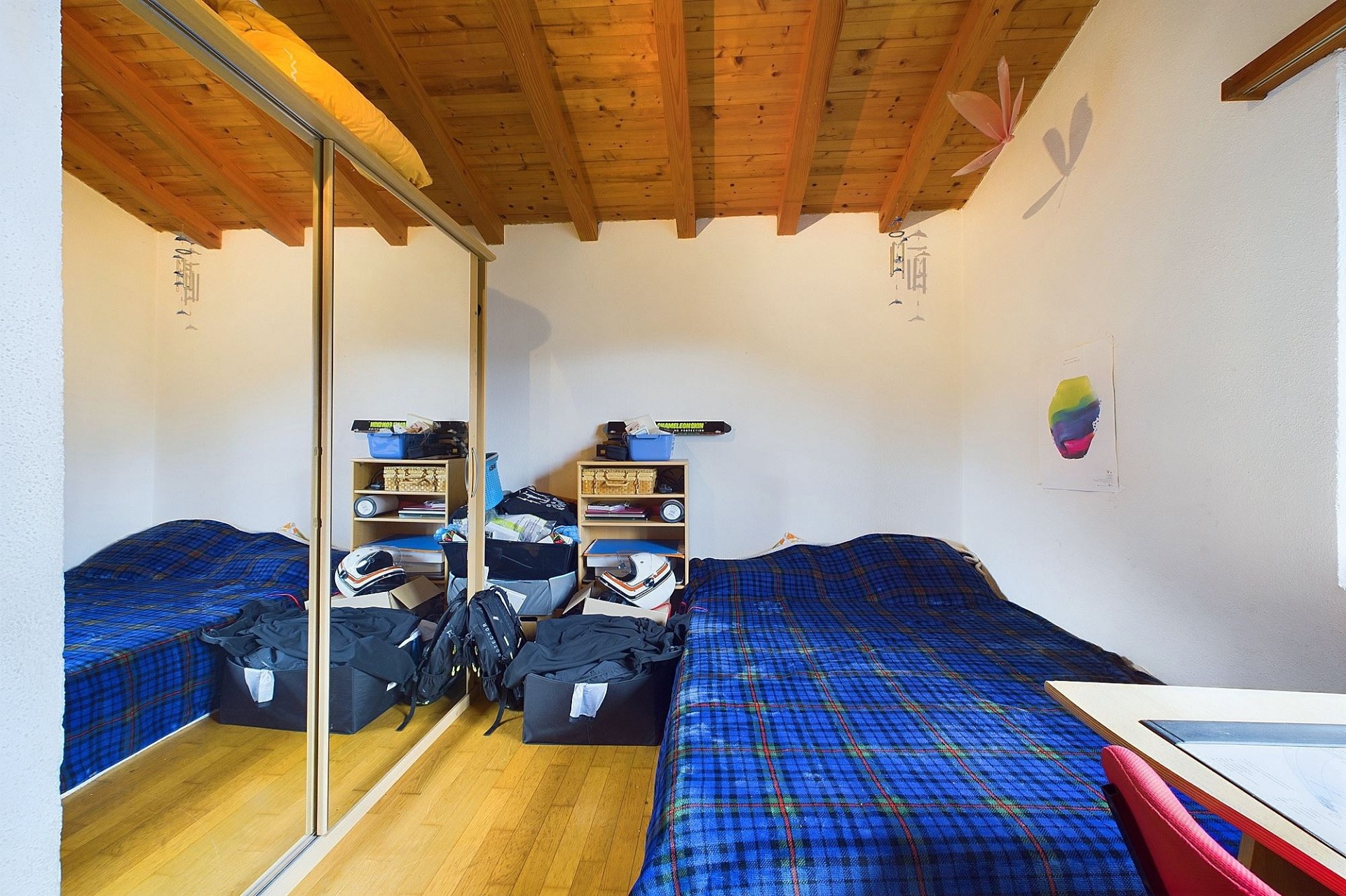 Kleines Schlafzimmer mit Holzdecke und Schiebetürenschrank