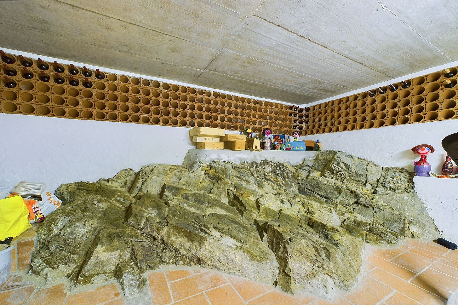 Weinkeller mit Steinstruktur und Flaschenregalen