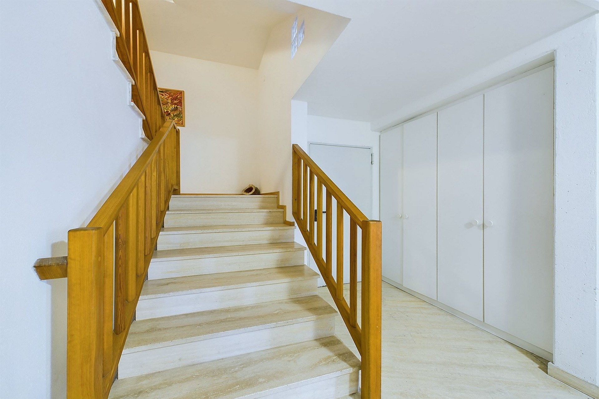 Treppenhaus mit Holzgeländer und Einbauschrank