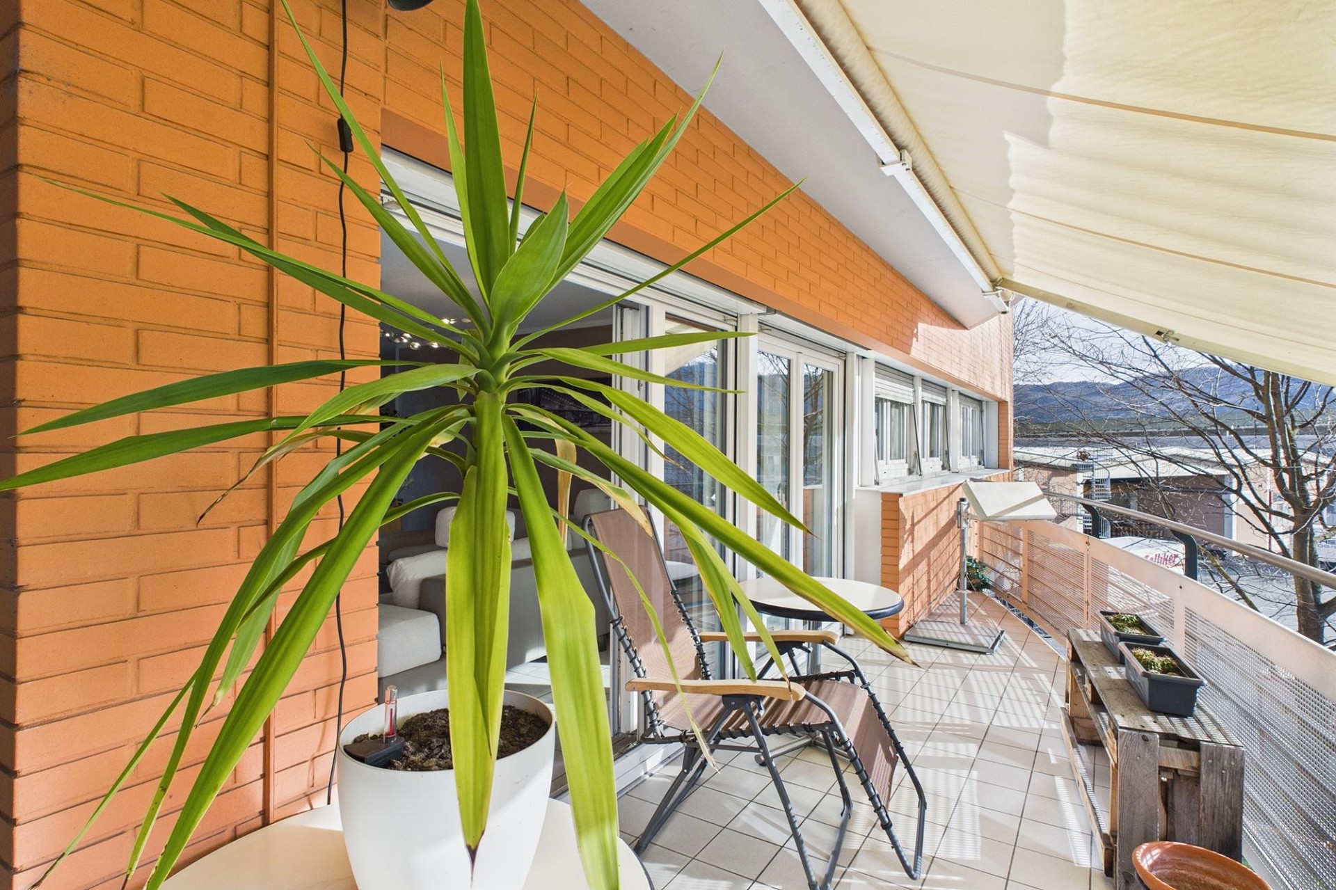 Balkon mit Pflanzen und Sitzgelegenheit