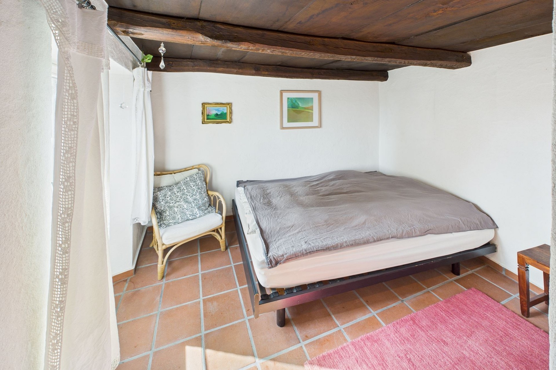 Kleines Schlafzimmer mit sichtbaren Holzbalken