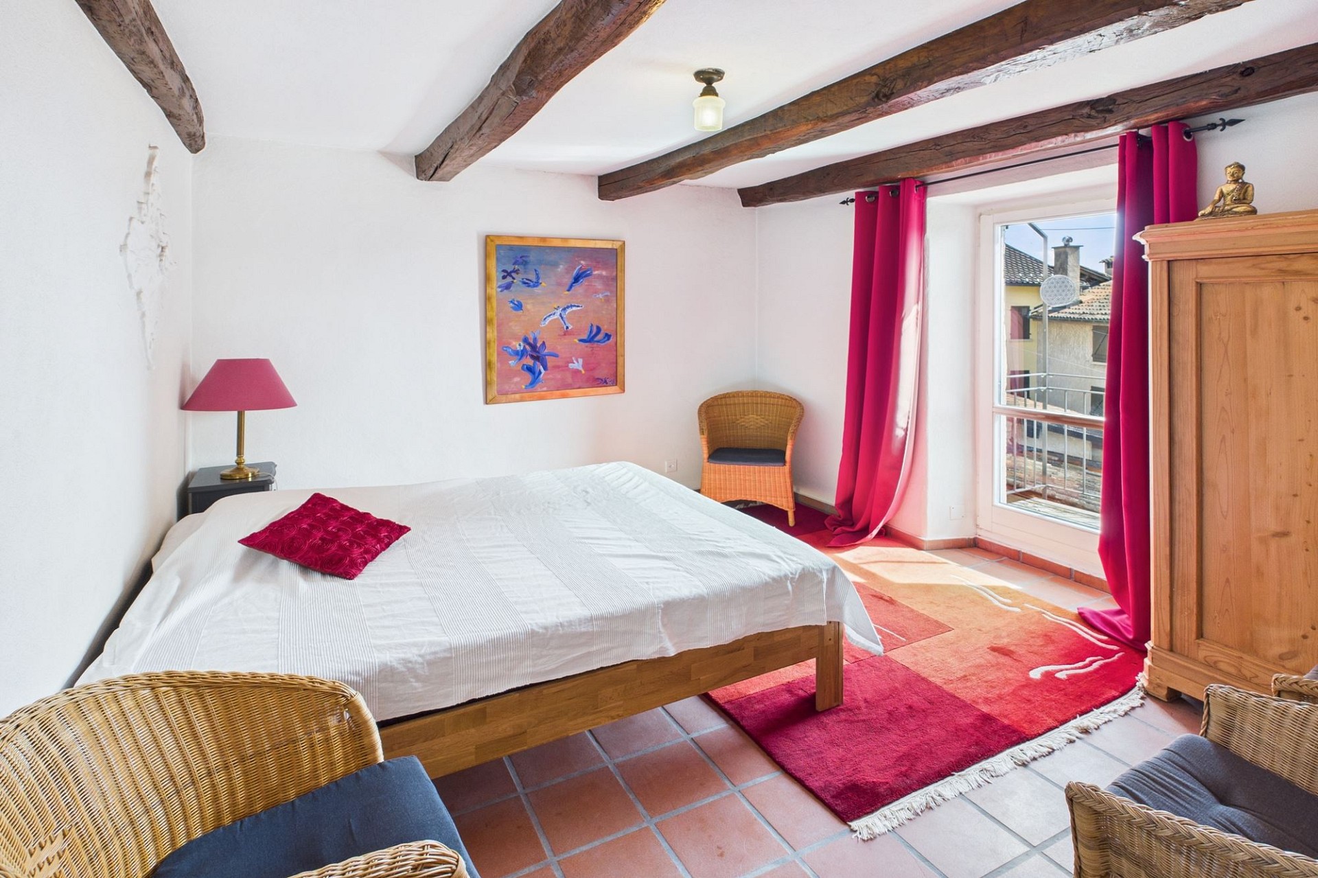 Helles Schlafzimmer mit rustikalen Balken und Balkonausblick