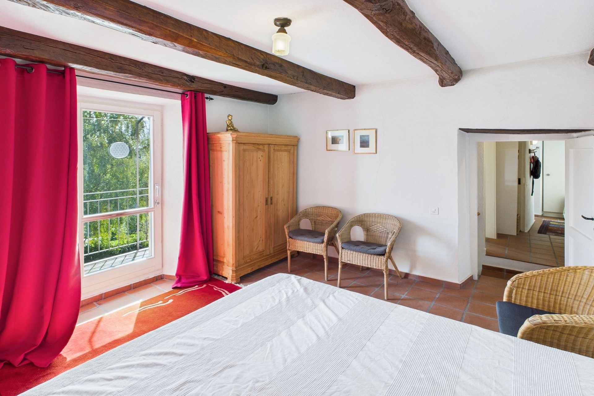 Rustikales Schlafzimmer mit Holzbalken und Balkonblick
