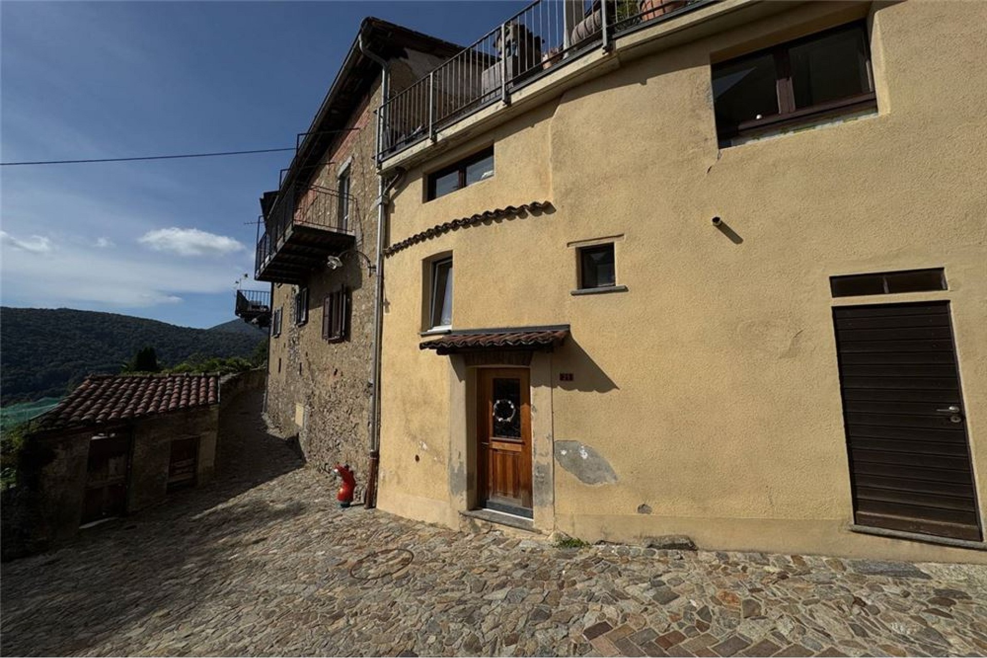 Historisches Wohnhaus mit Balkonen und Natursteinpflaster