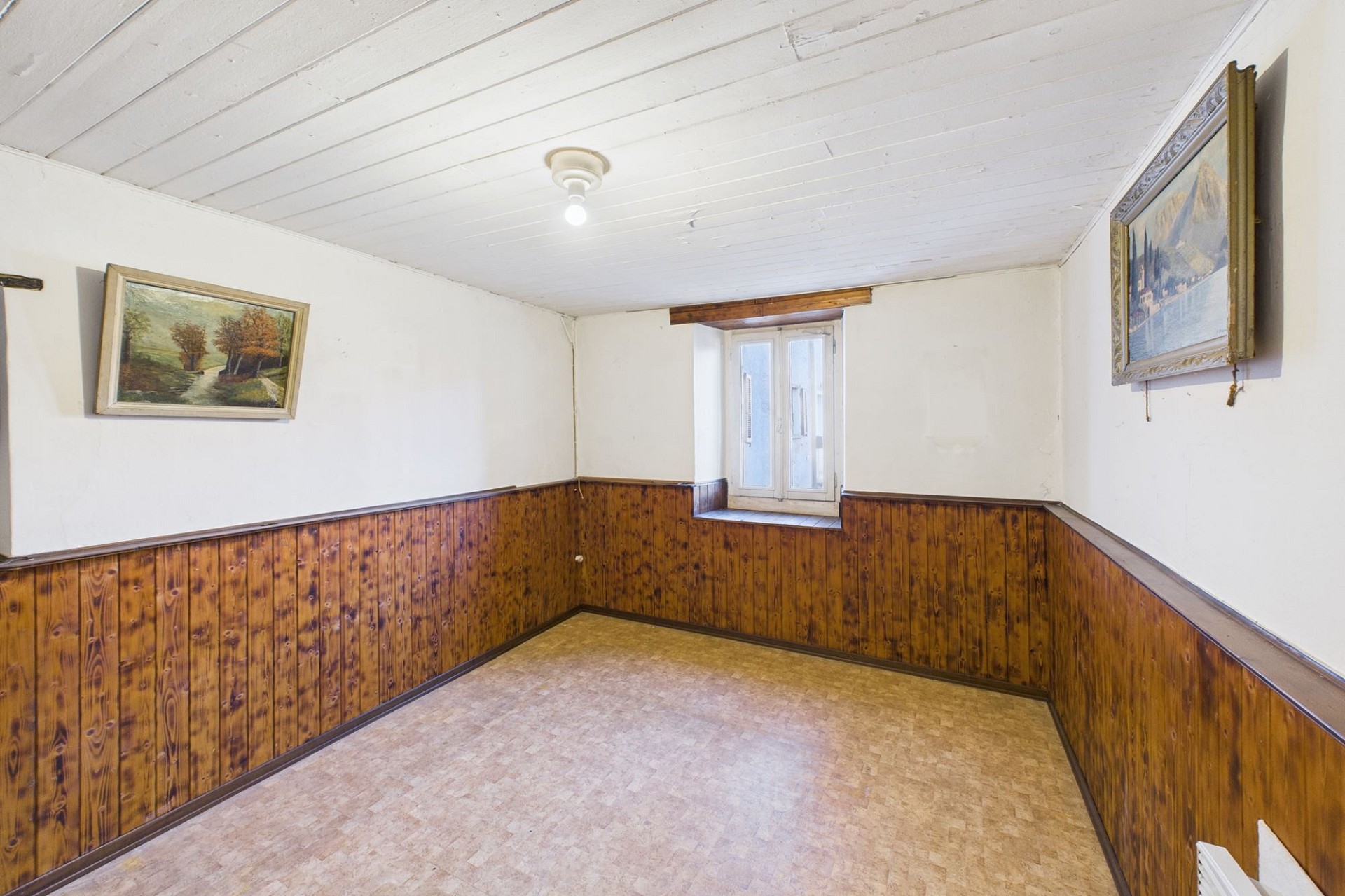 Ein kleiner leerer Raum mit Holzvertäfelung und Fensterbank