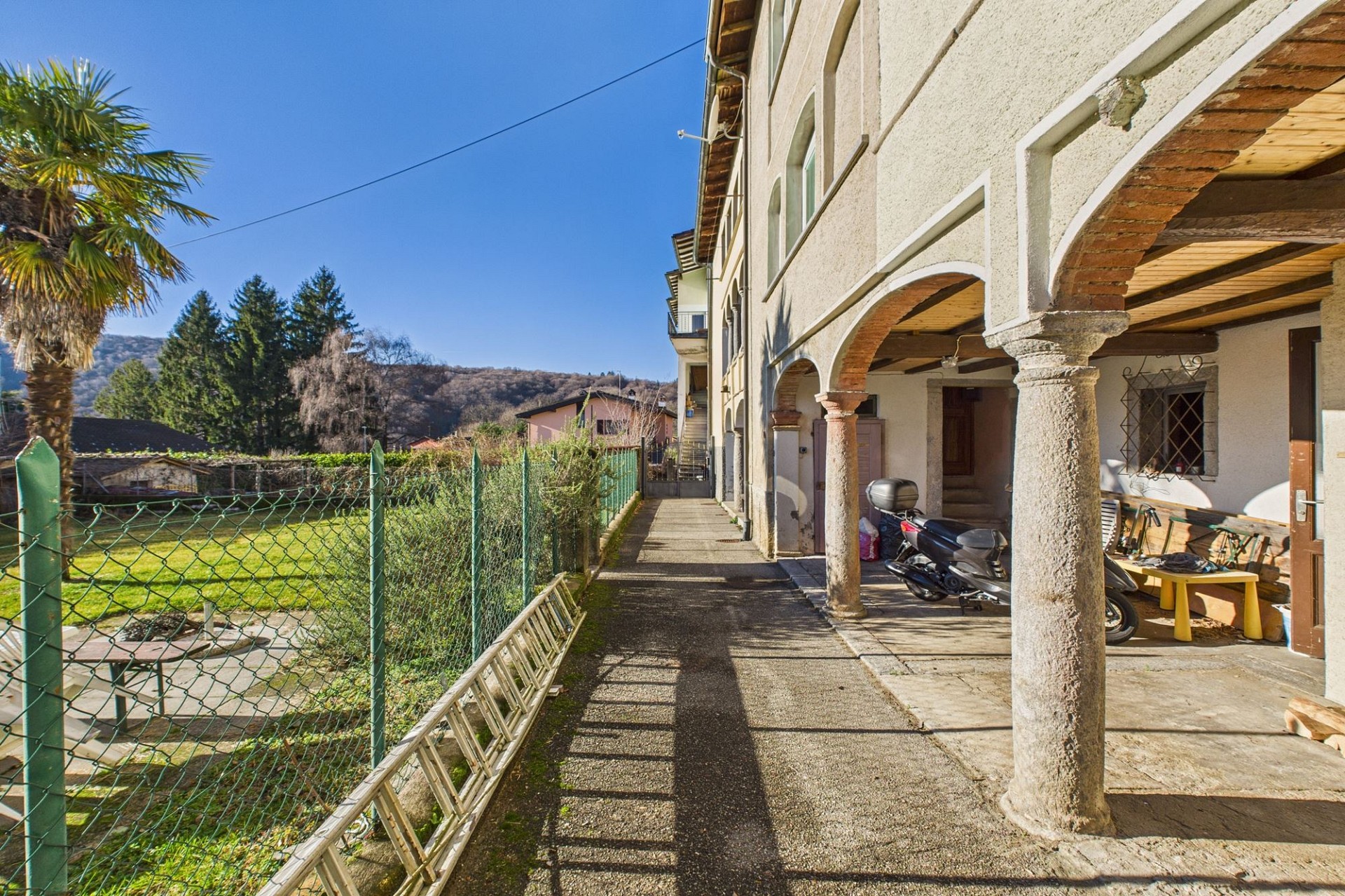 Außenansicht eines Hauses mit überdachtem Gang und Garten
