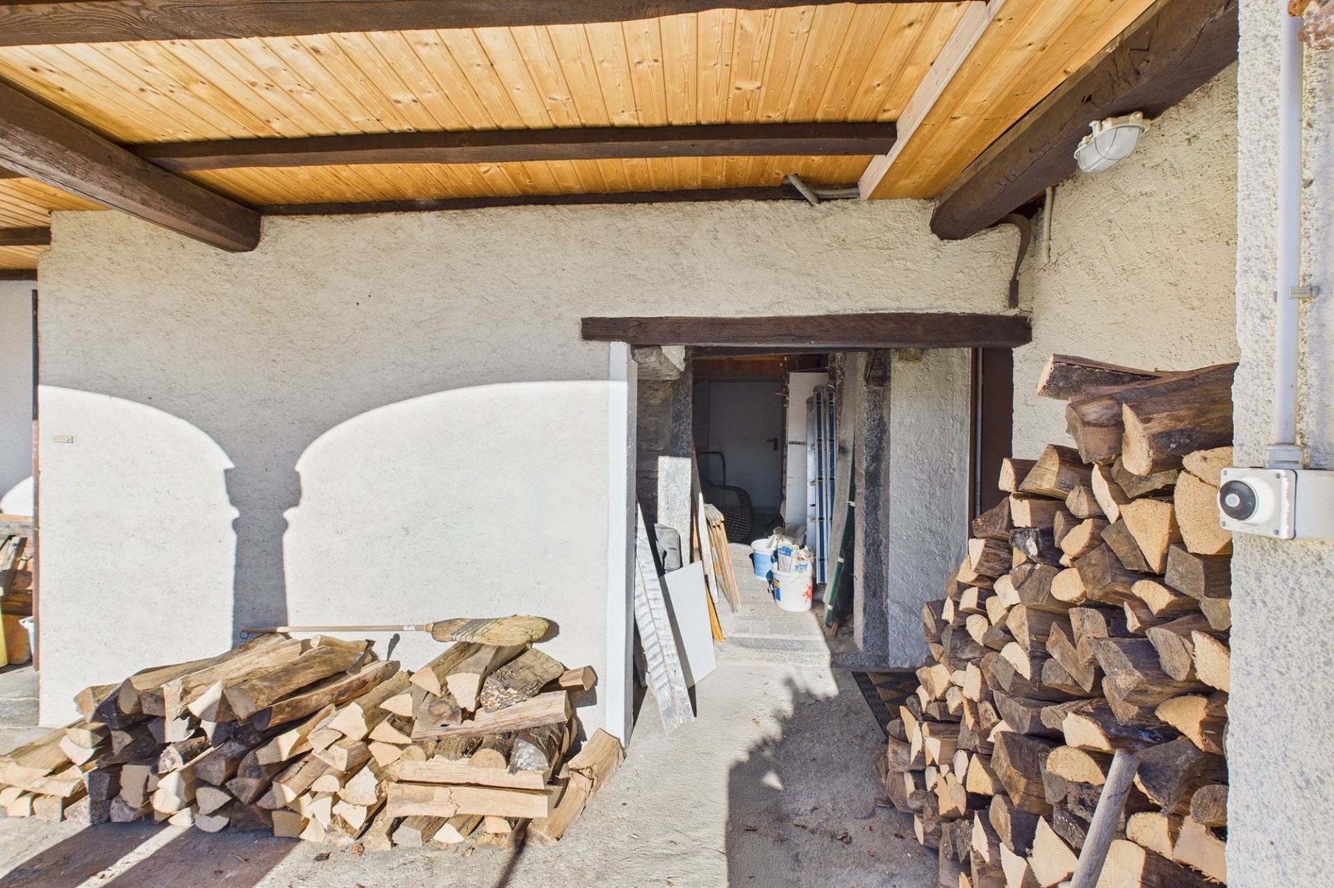 Überdachter Außenbereich mit Holzlager