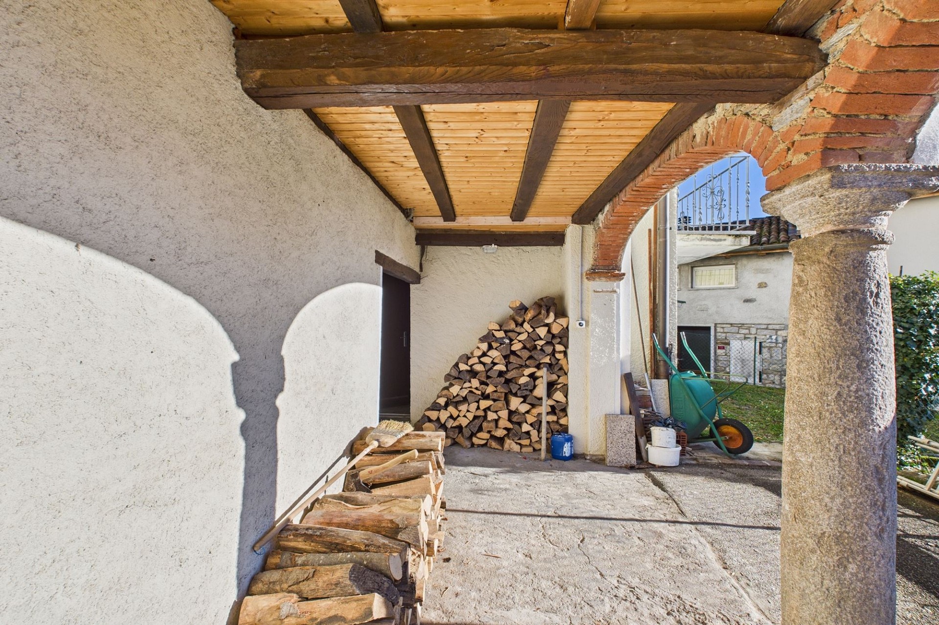 Überdachter Außenbereich mit Holzstapel