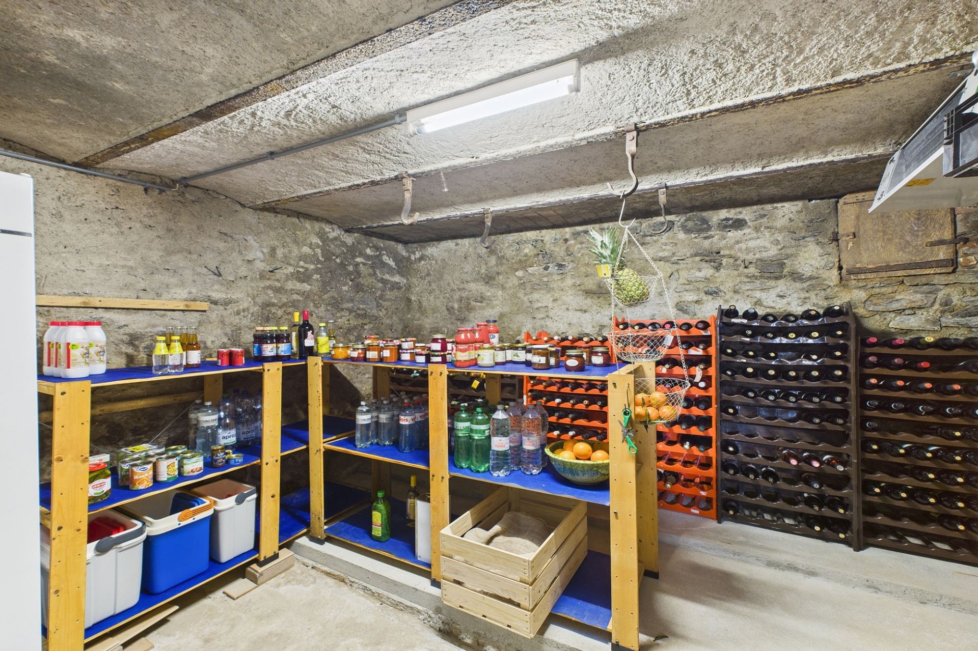 Gewölbter Keller mit Vorratsregalen und Weinlagern