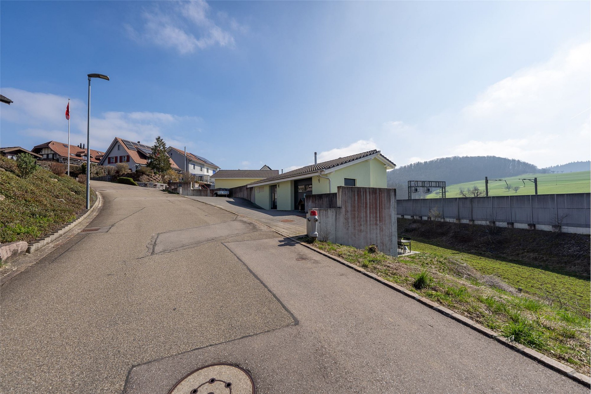 Wohnstraße mit Hanglage und Einfamilienhäusern