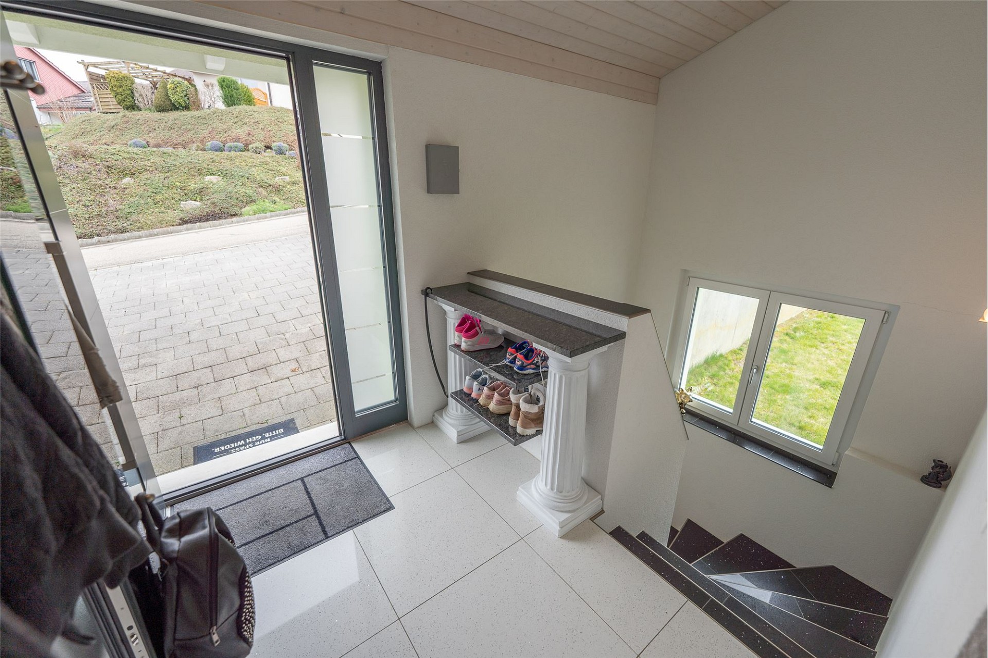 Heller Eingangsbereich mit Treppe und Fensterblick