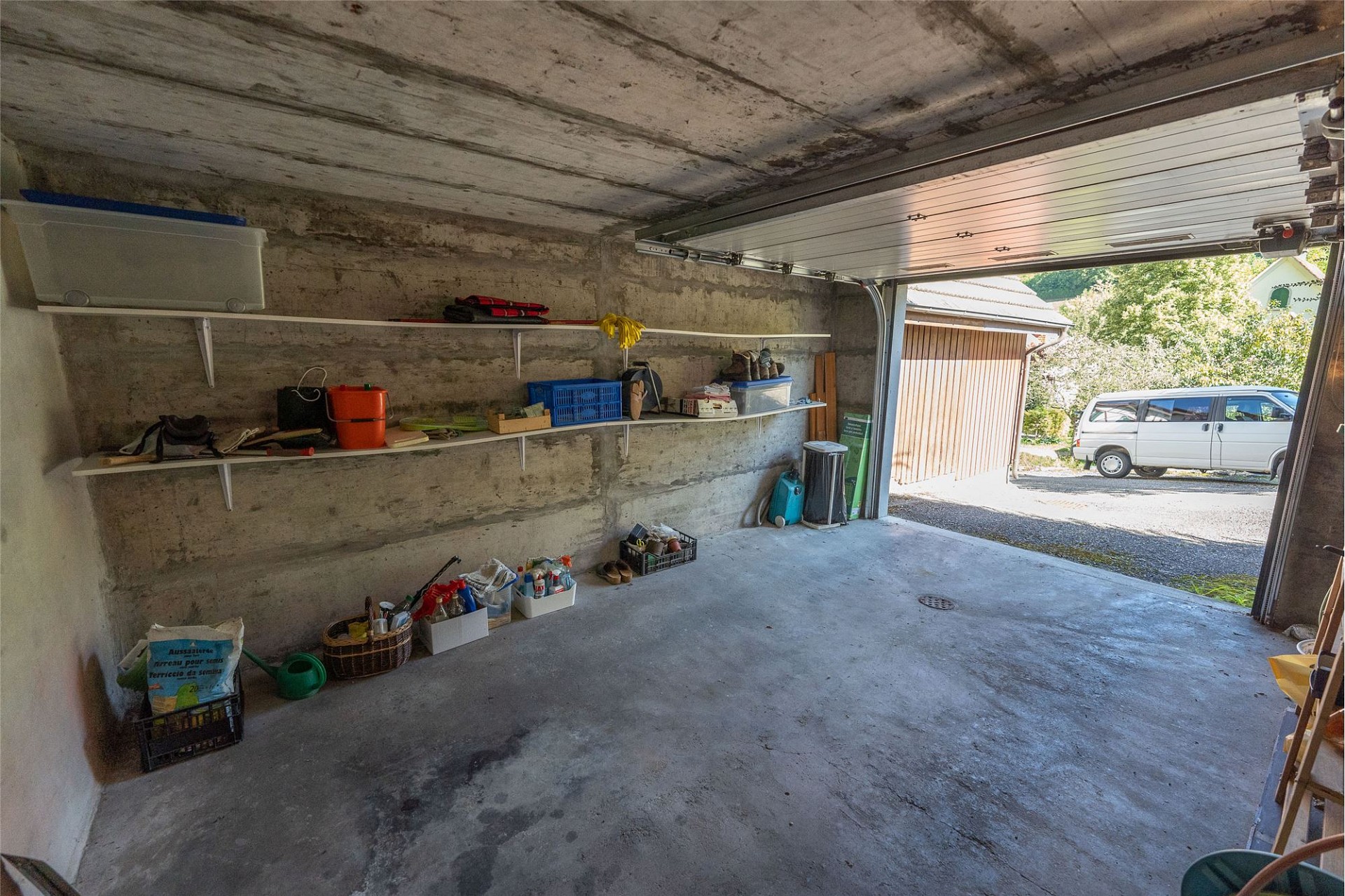 Garage mit offenem Tor und Abstellregalen