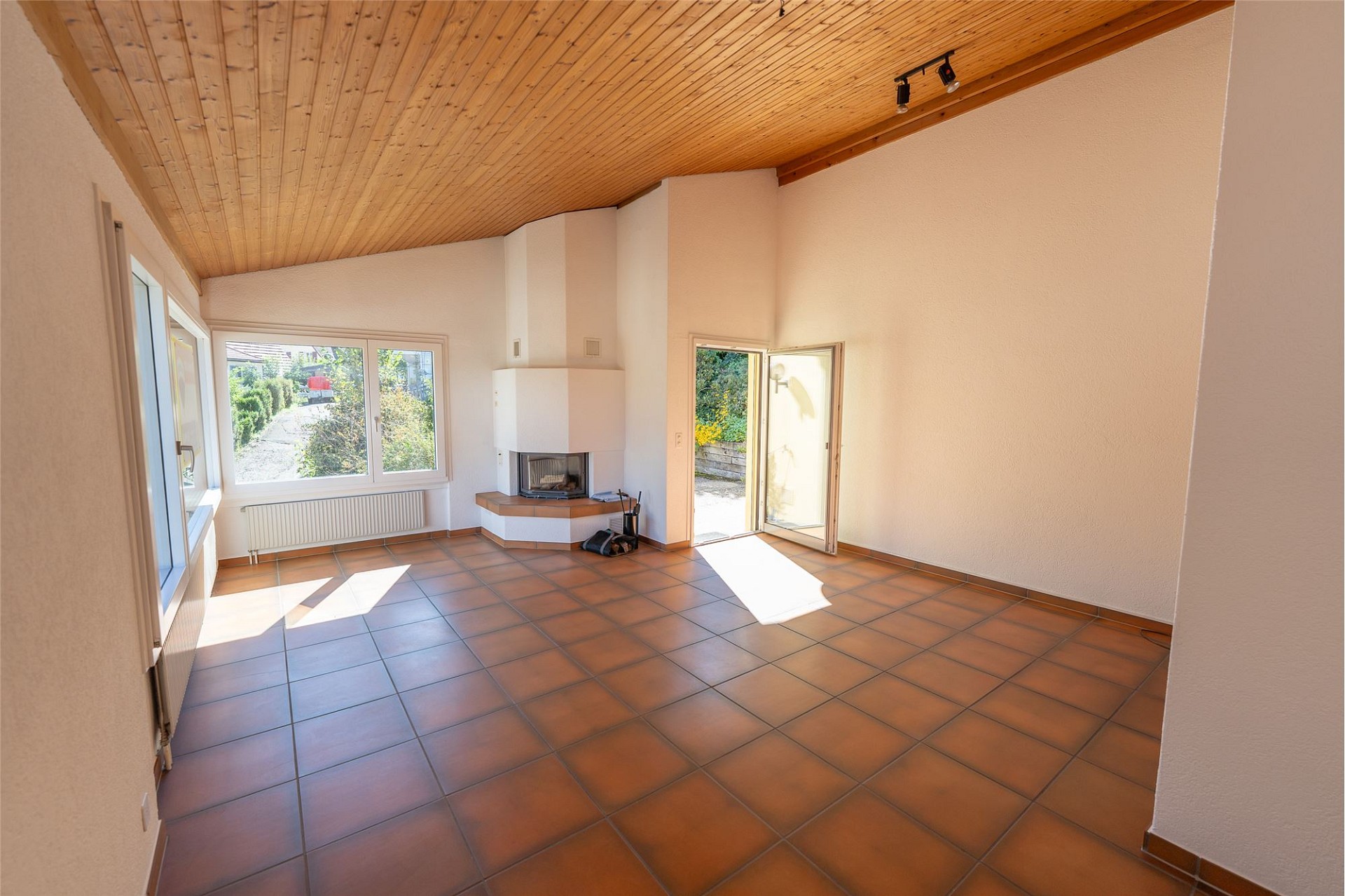 Heller Wohnraum mit Kamin und Terrassenzugang