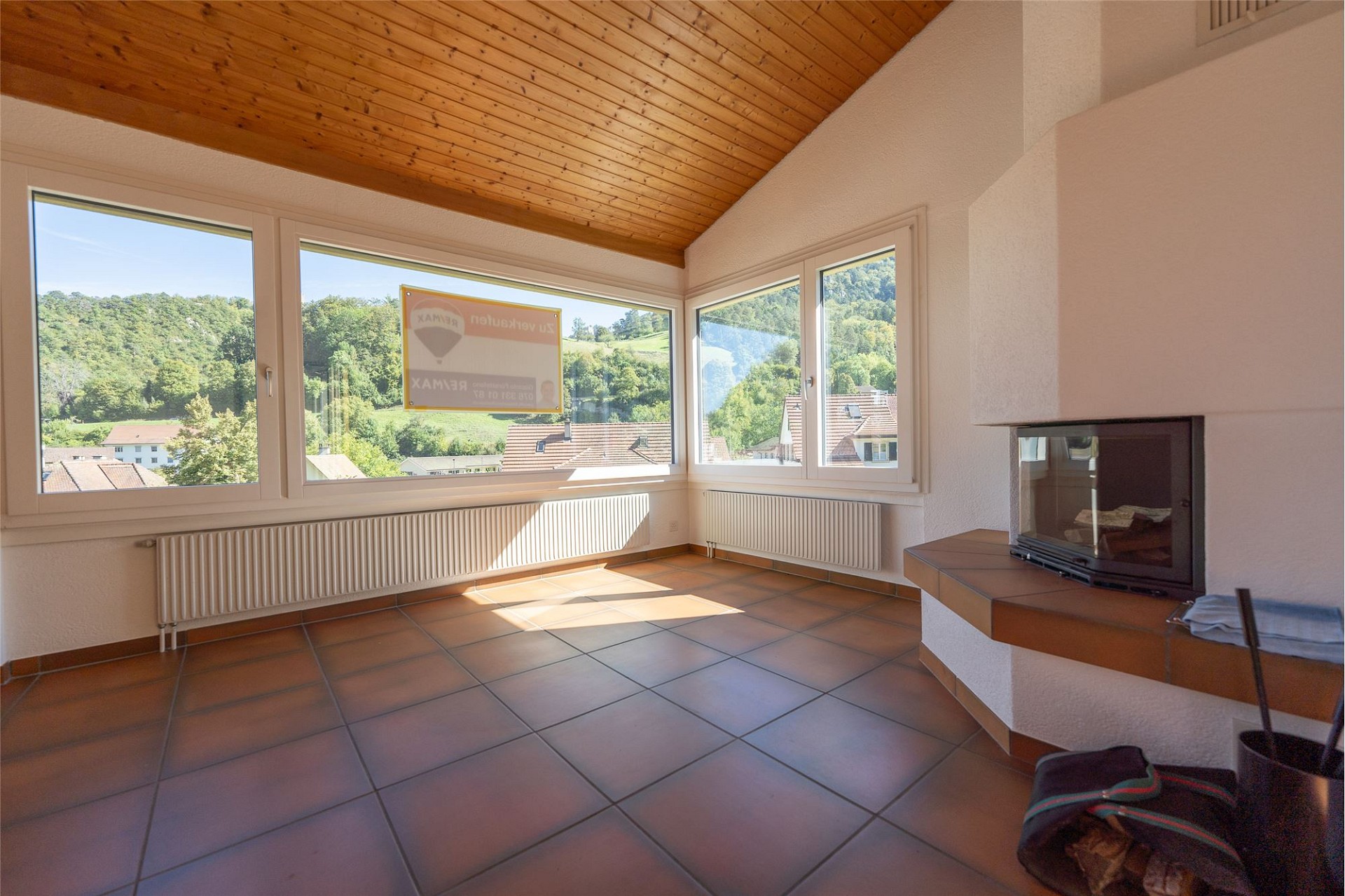 Heller Wohnraum mit Kamin und Panoramafenstern