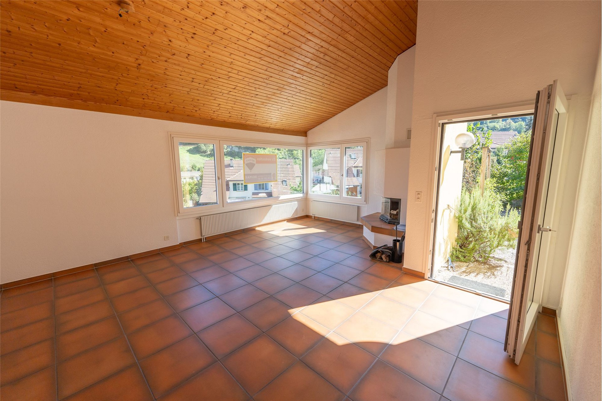 Heller Wohnraum mit Holzdecke und Terrakottafliesen