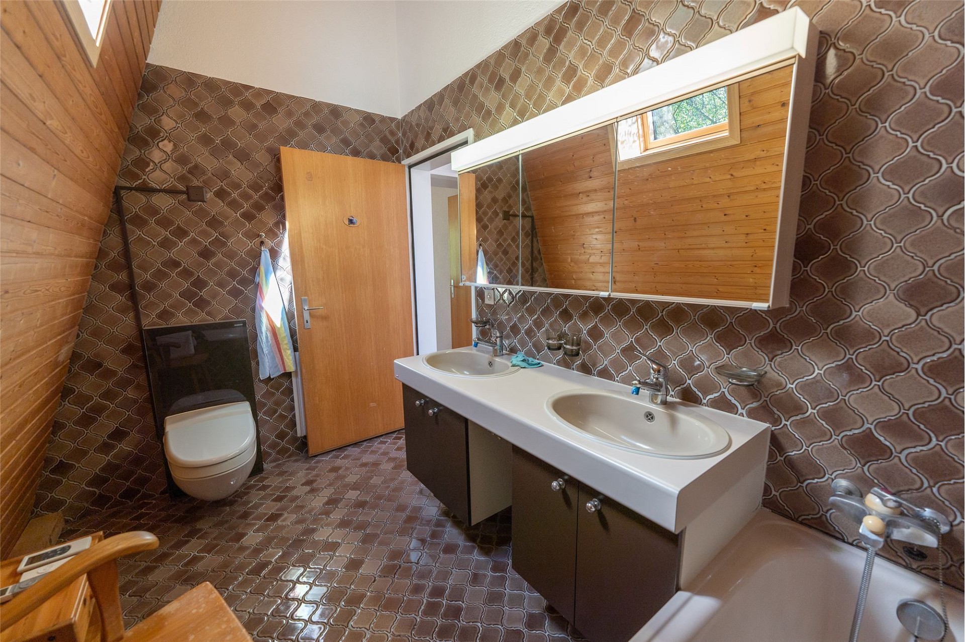 Badezimmer mit Retro-Tapete und Doppelwaschtisch