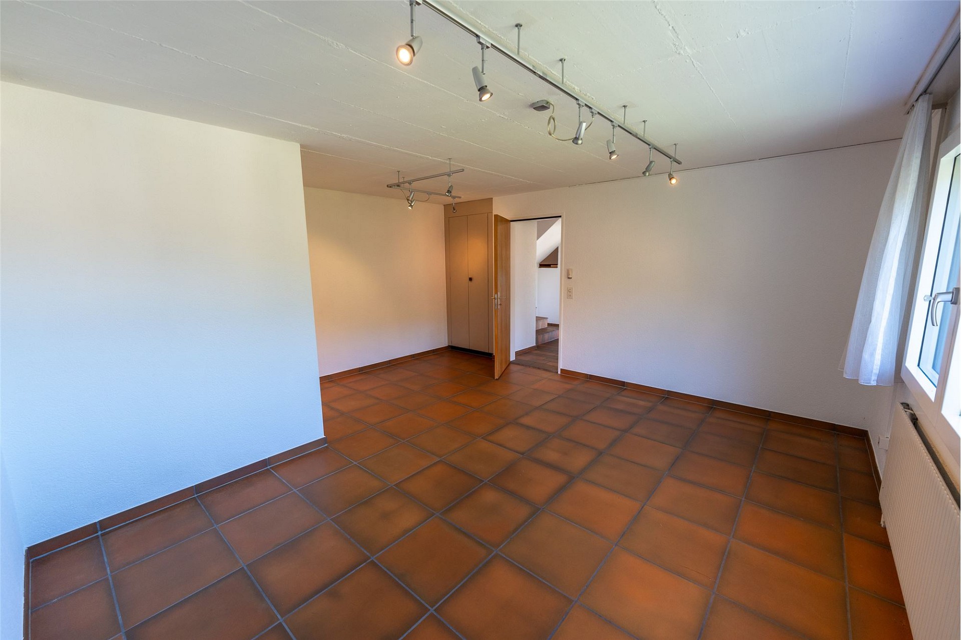 Leerer Raum mit Terrakottafliesen und Einbauschrank