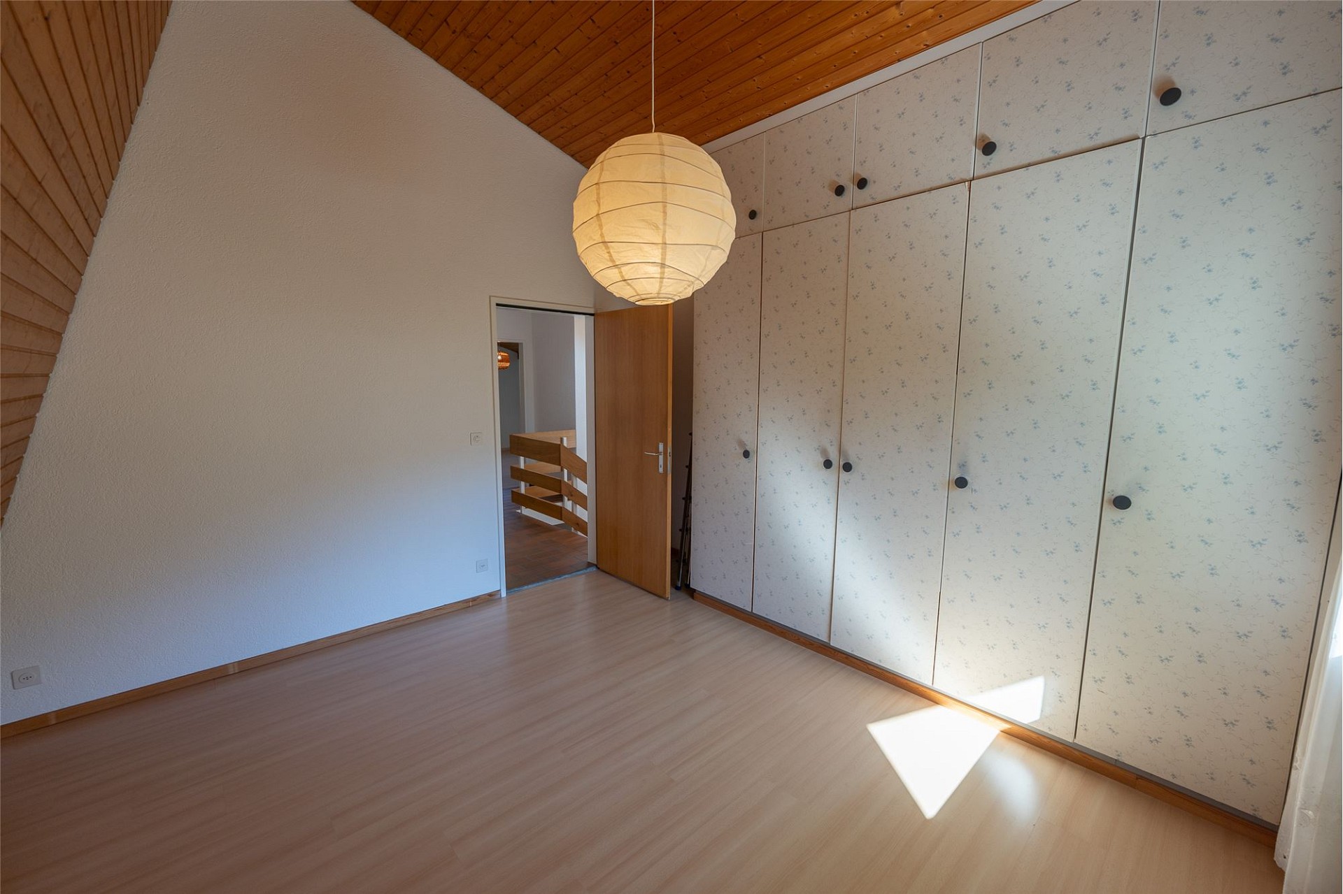 Helles Schlafzimmer mit Einbauschrank und Holzdecke