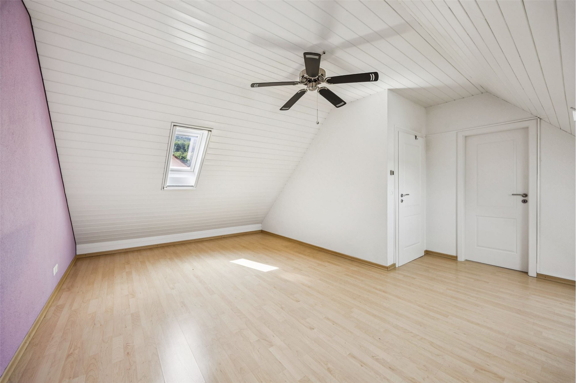 Heller Dachraum mit Laminatboden und Deckenventilator