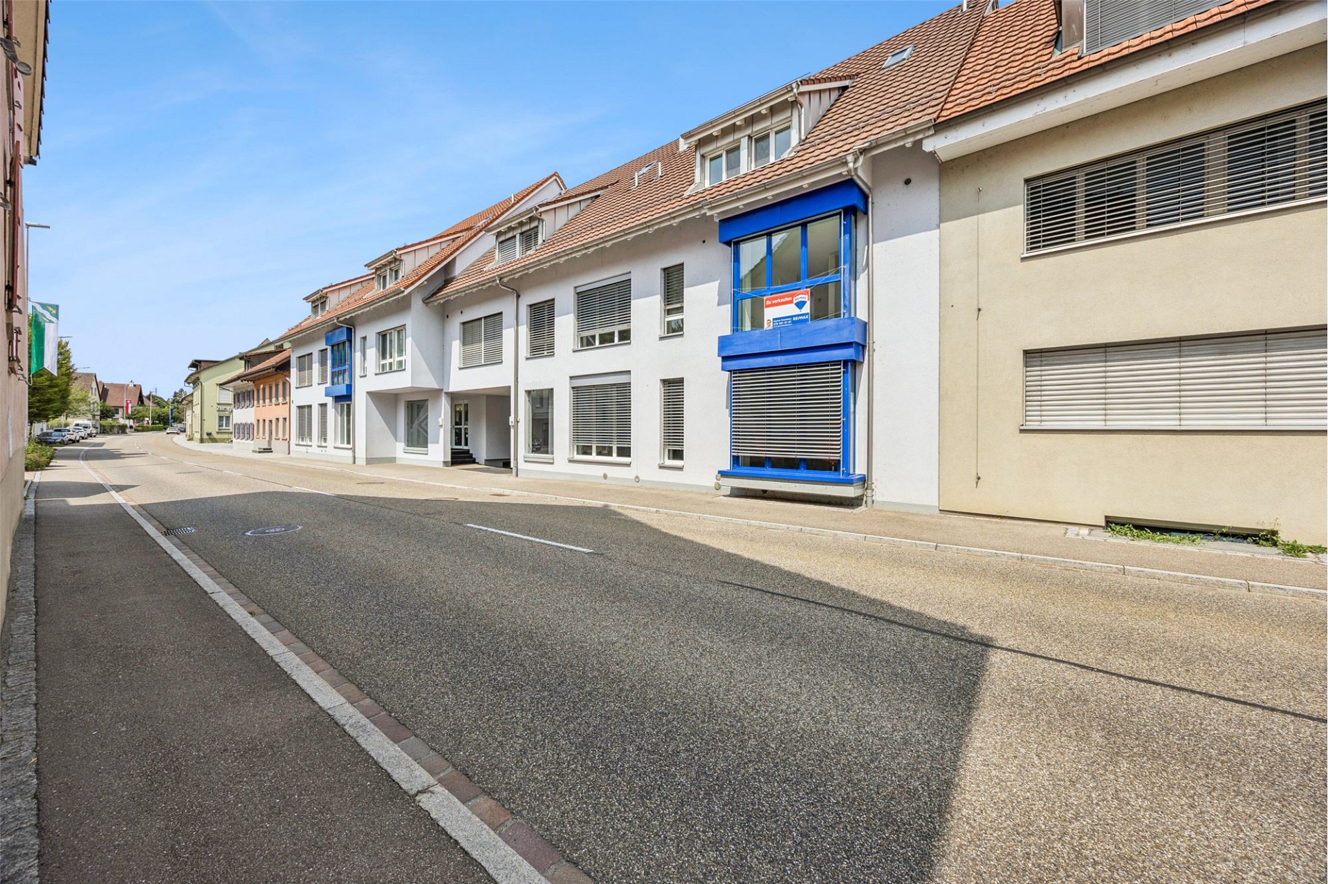 Straßenansicht eines Wohn- und Geschäftshauses mit Schrägdach