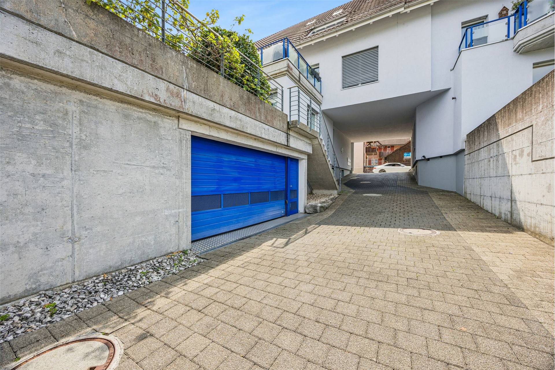 Zufahrt mit Garagen und Wohngebäude