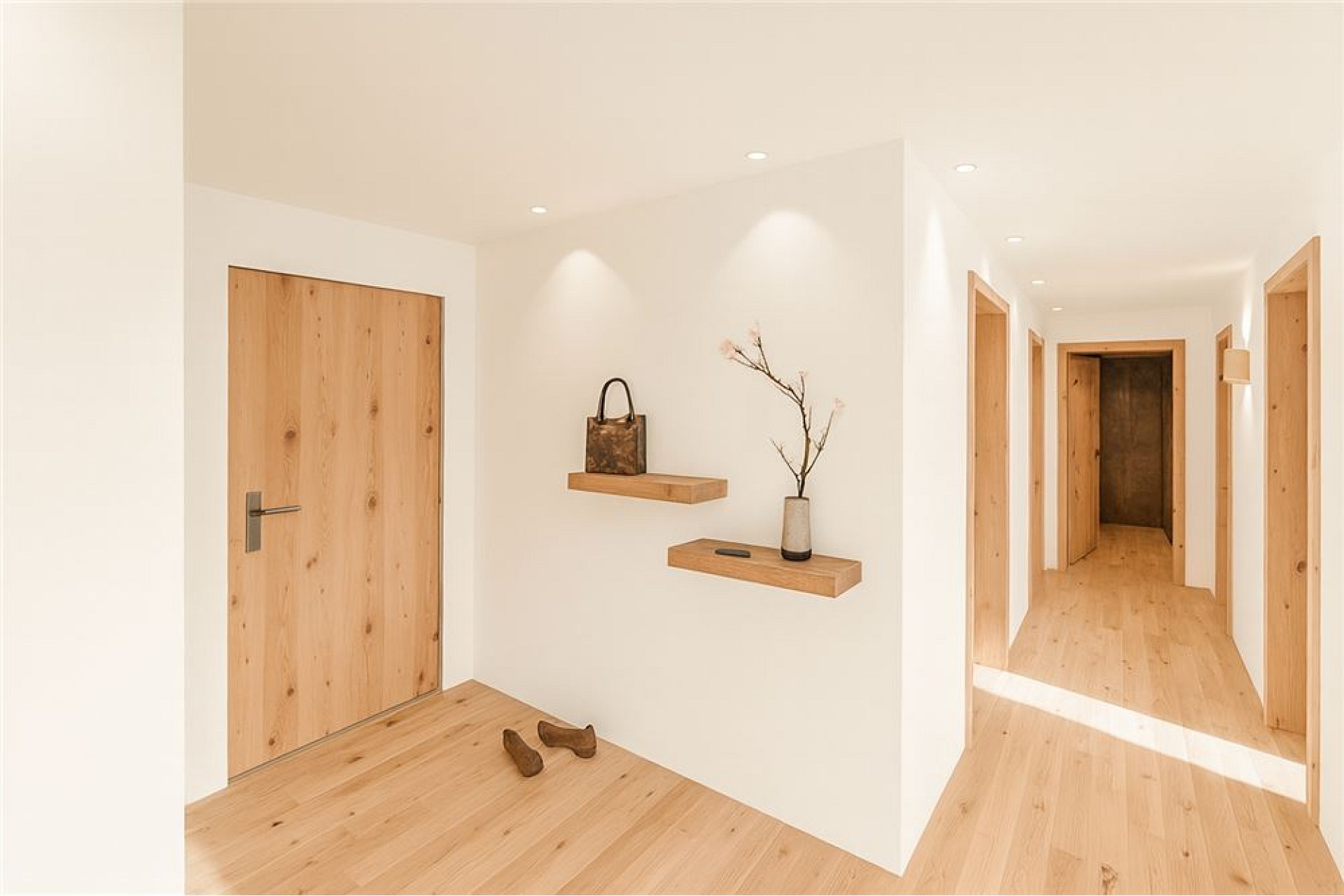 Heller Flur mit Holztüren und Eichenboden