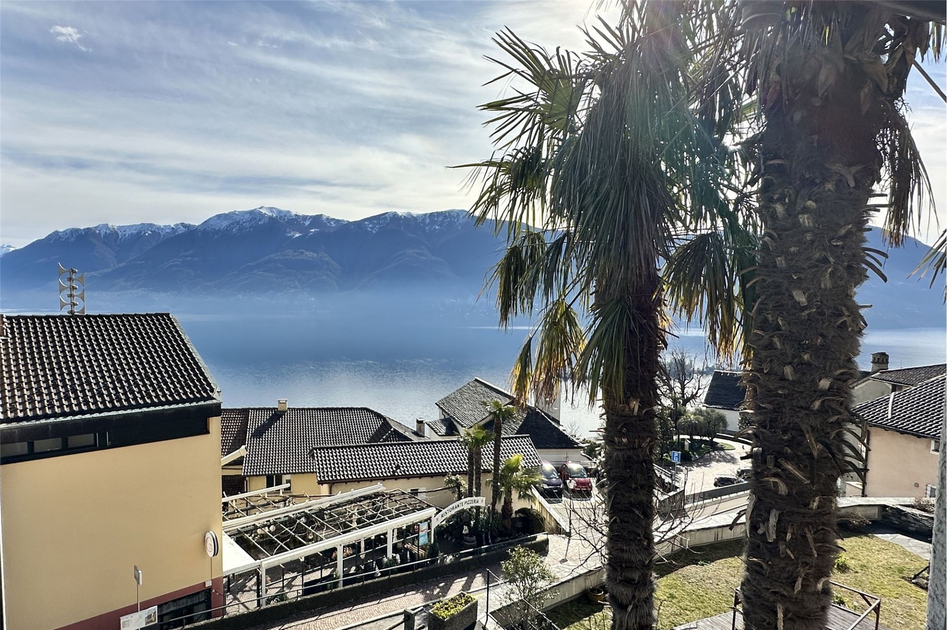 Seeblick mit Bergen und Palmen