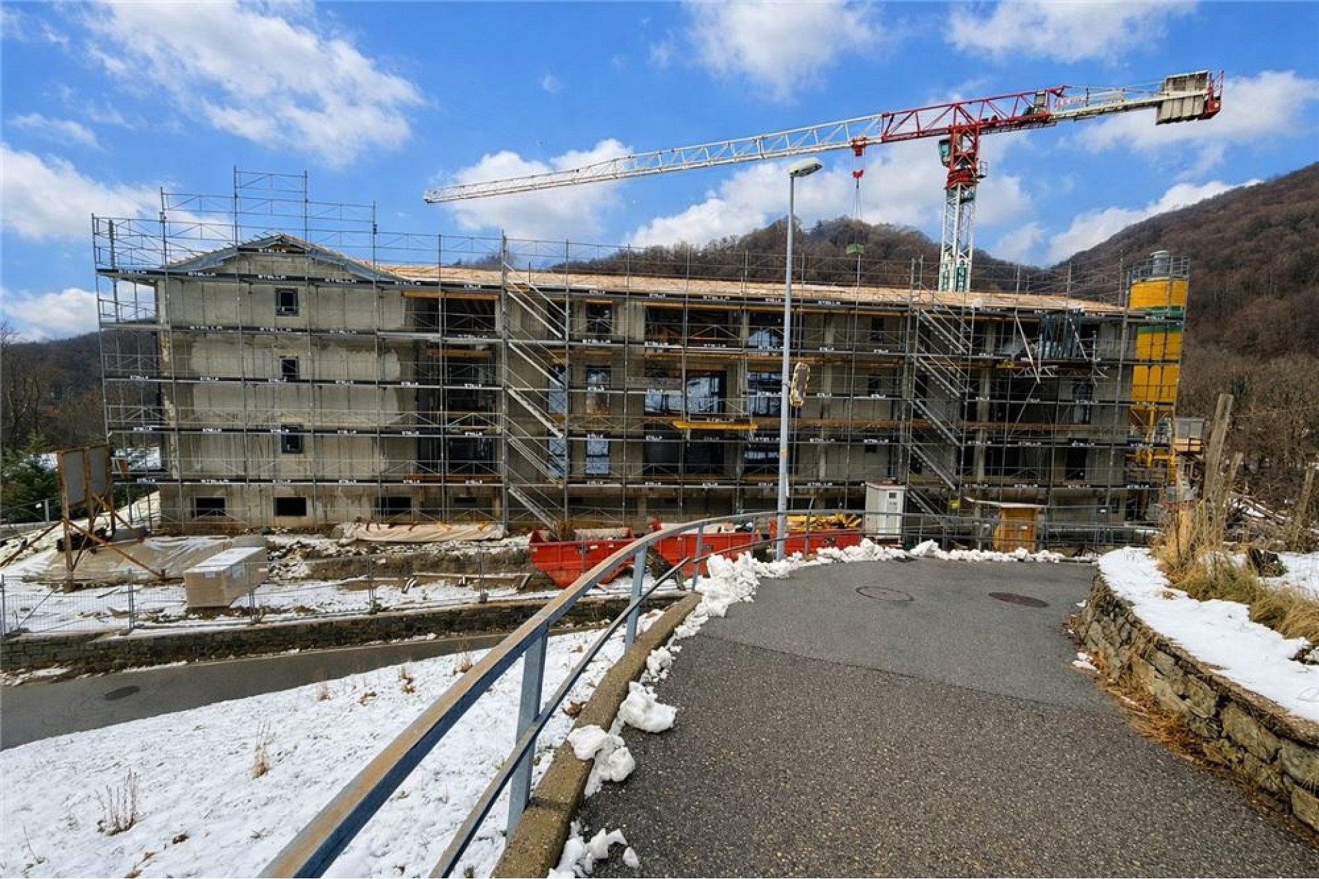 Mehrfamilienhaus im Bau mit Gerüst und Kran