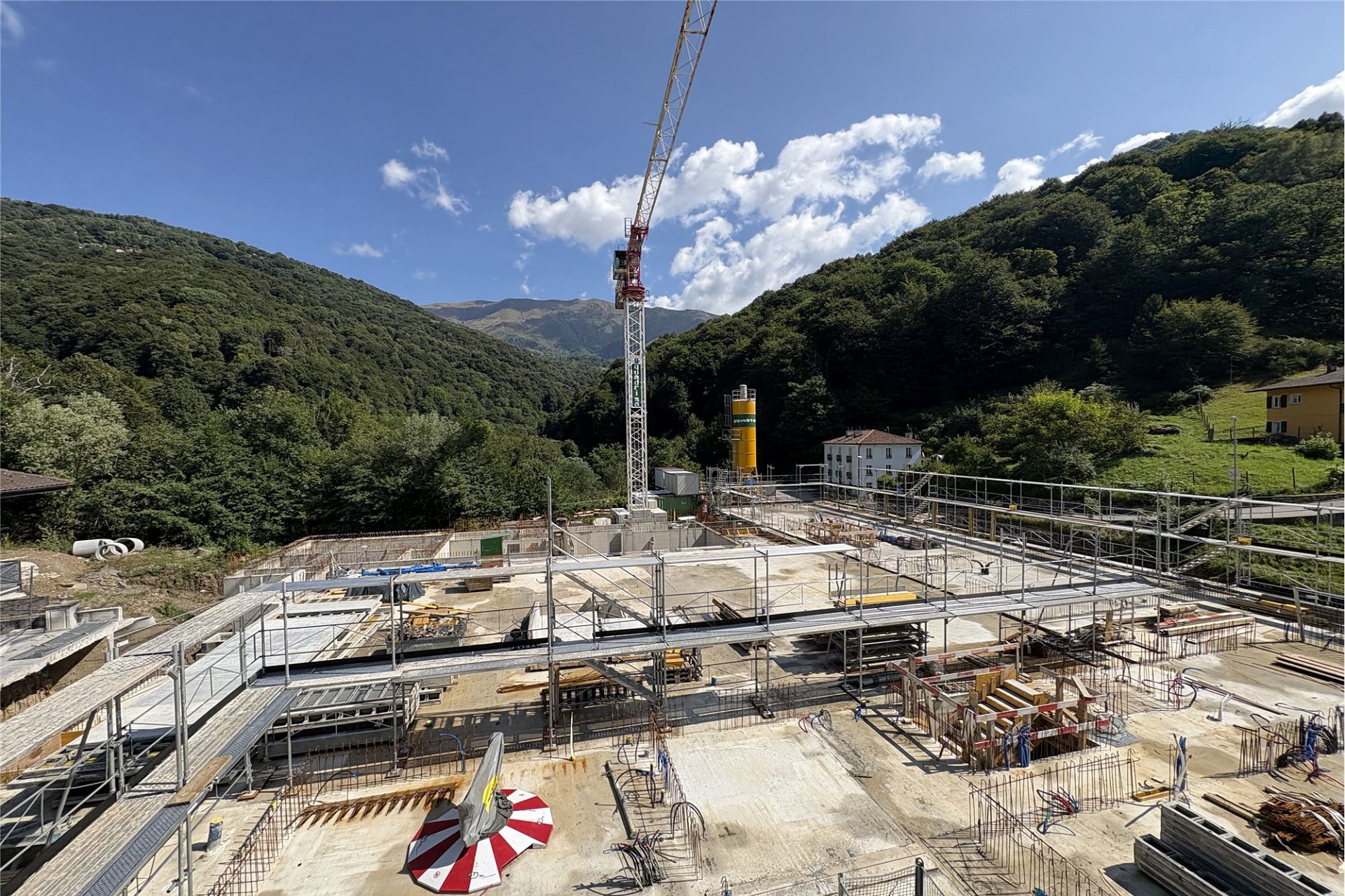 Baugrundstück mit Rohbau und Kran in Berglage