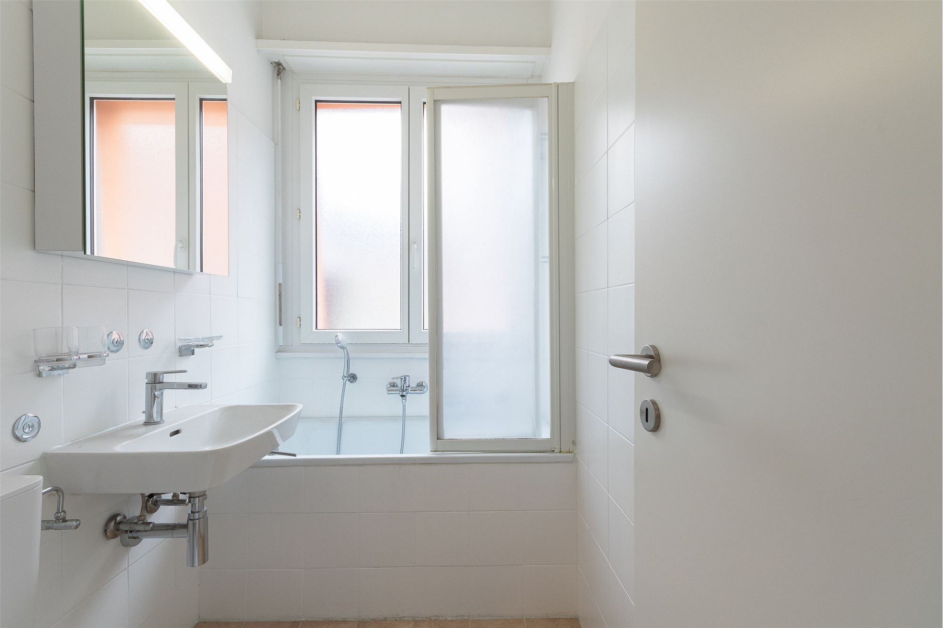 Helles Badezimmer mit Badewanne und Fenster