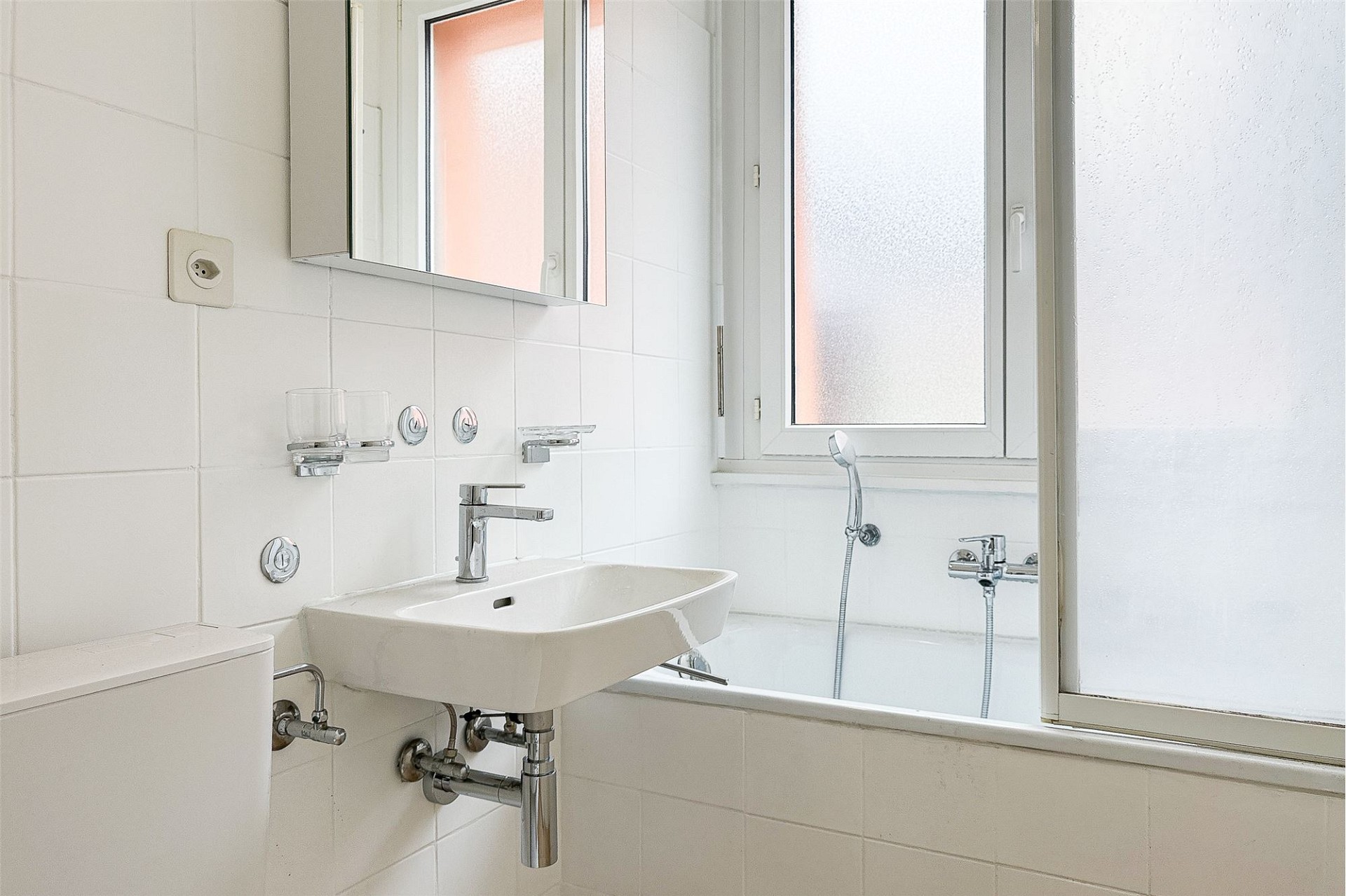 Kleines helles Badezimmer mit Badewanne und Waschbecken