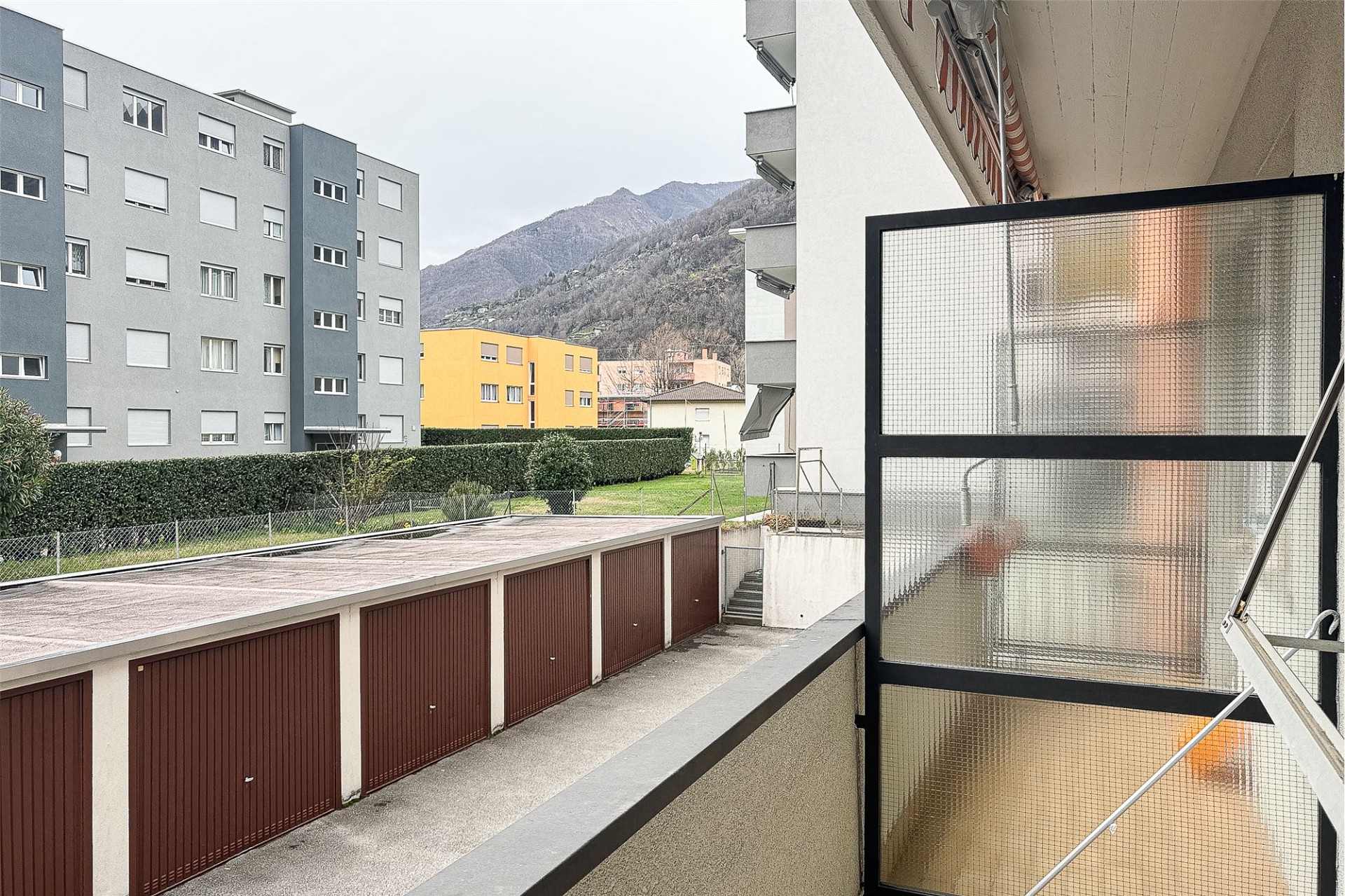 Balkon mit Blick auf Wohnanlage und Berge