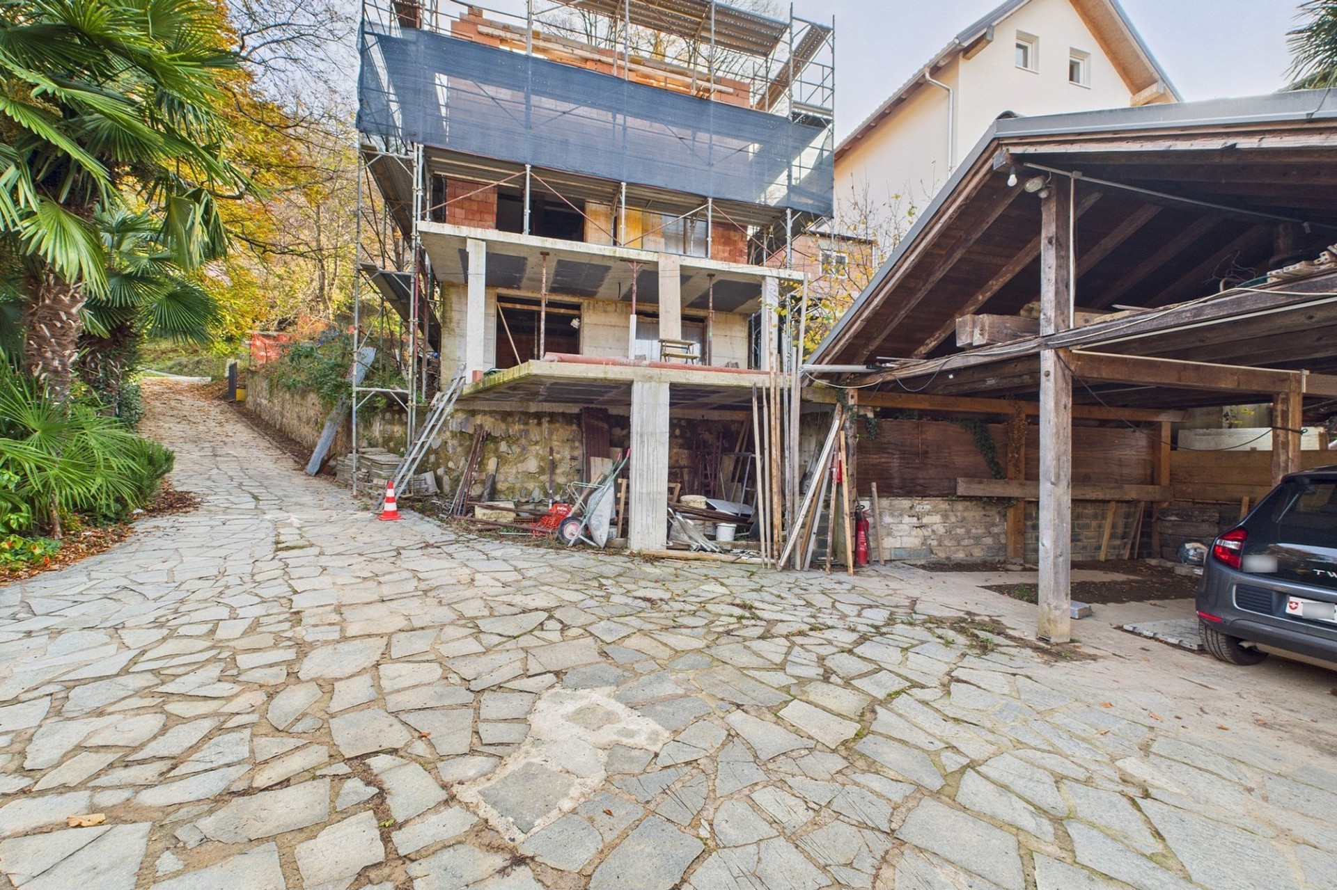 Außenansicht eines Hauses mit Baustelle und Carport