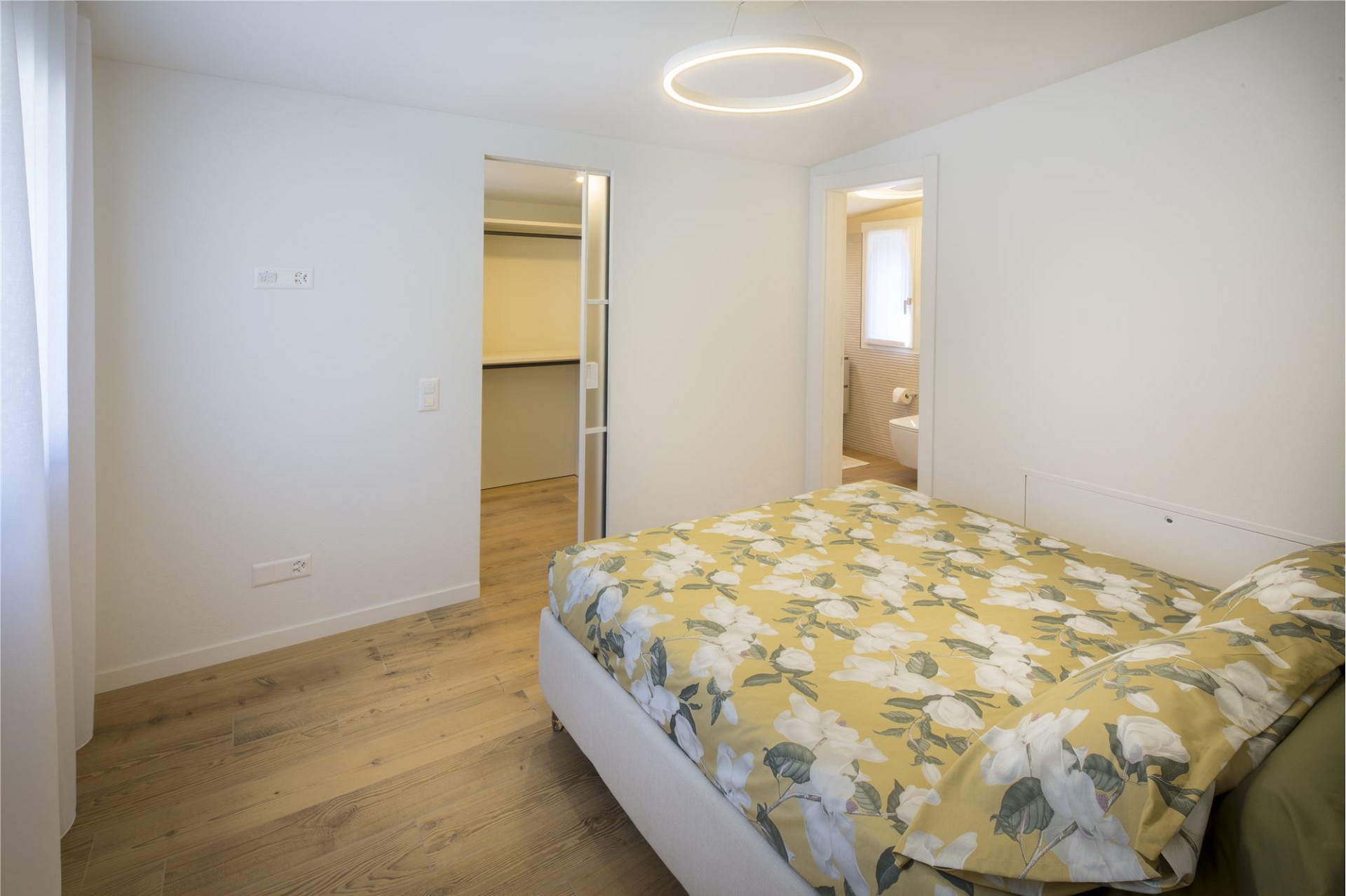 Helles Schlafzimmer mit Blick ins Bad
